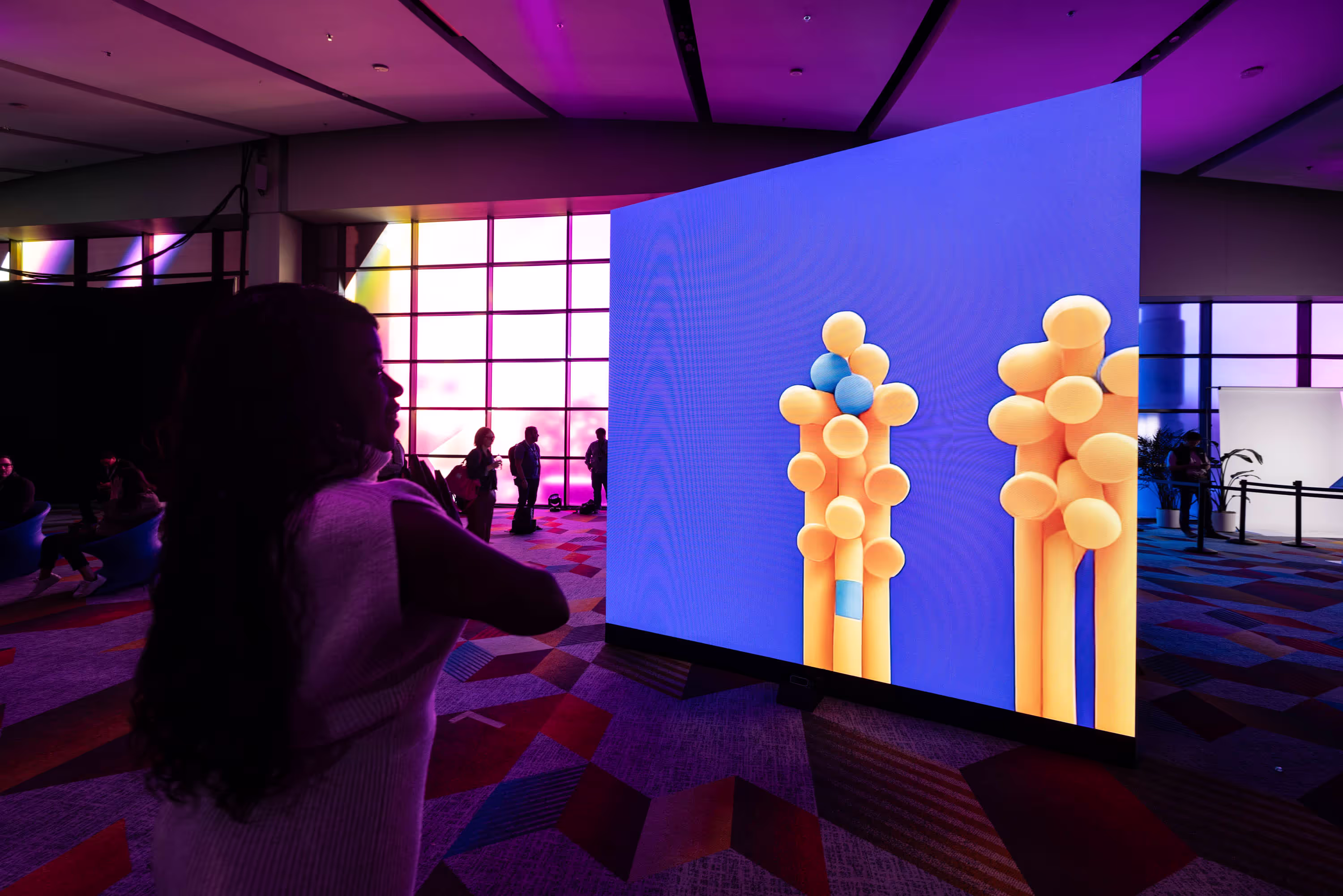 A woman standing in front of a large screen