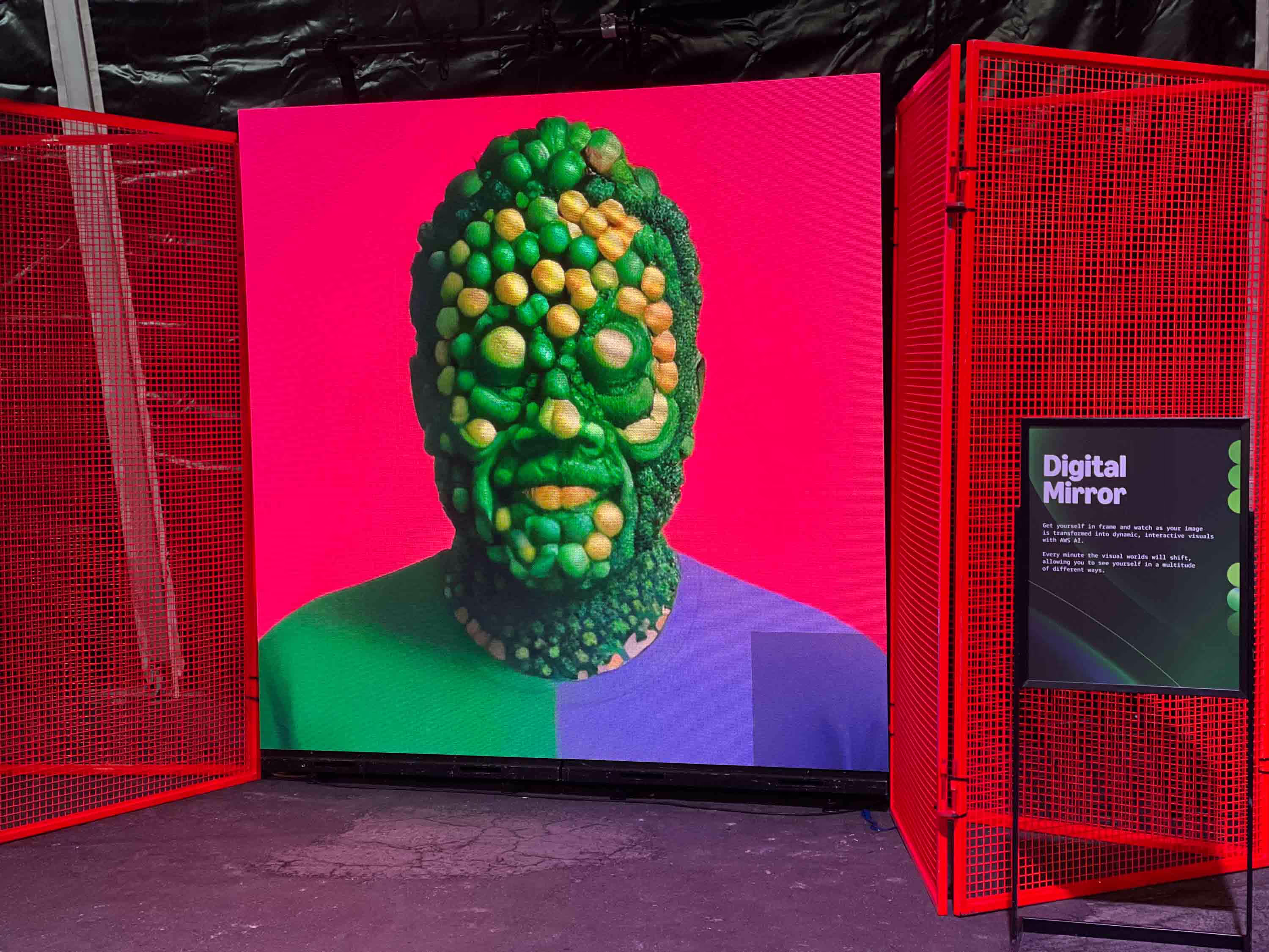 A large screen with a man's head made out of vegetables