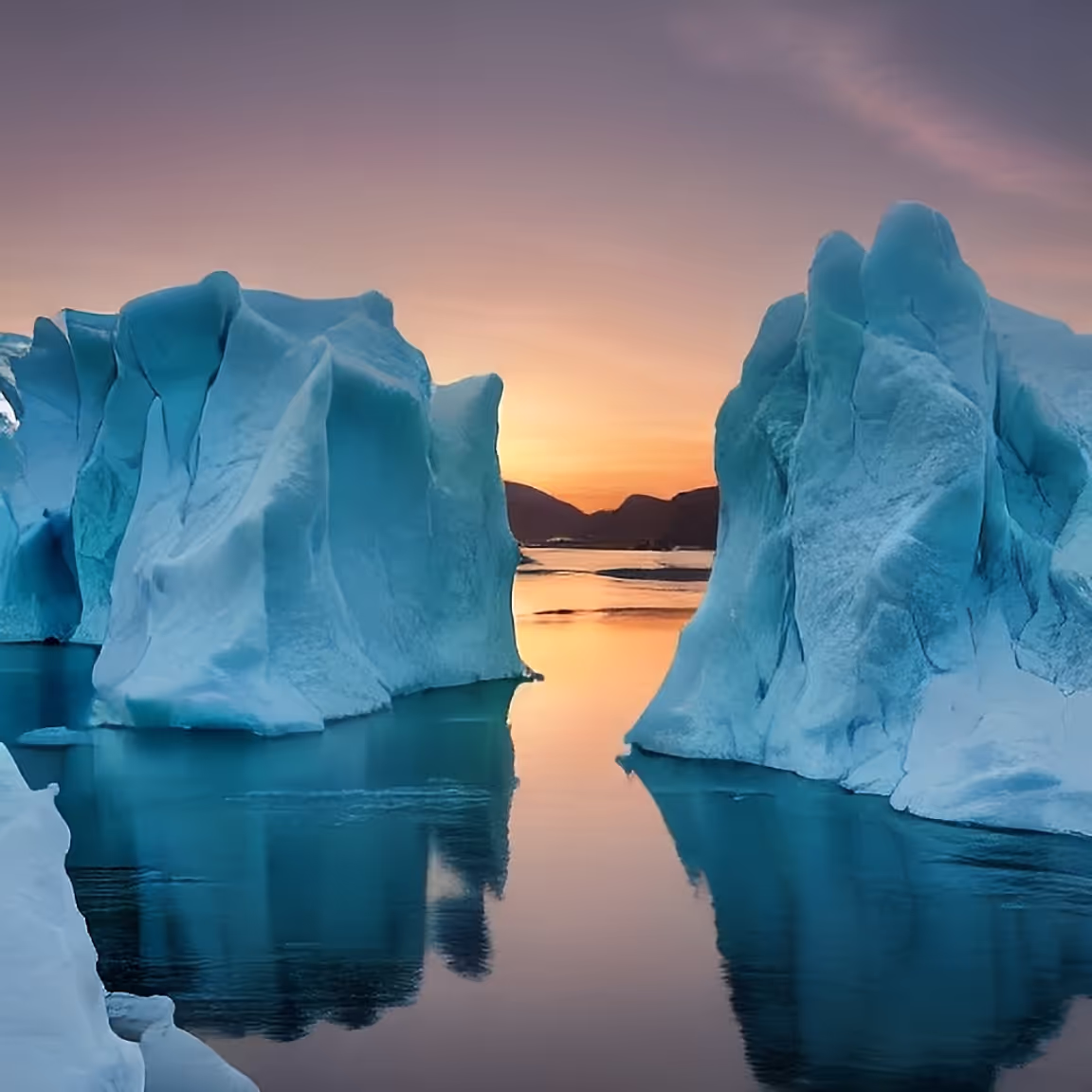 A group of icebergs floating on top of a body of water