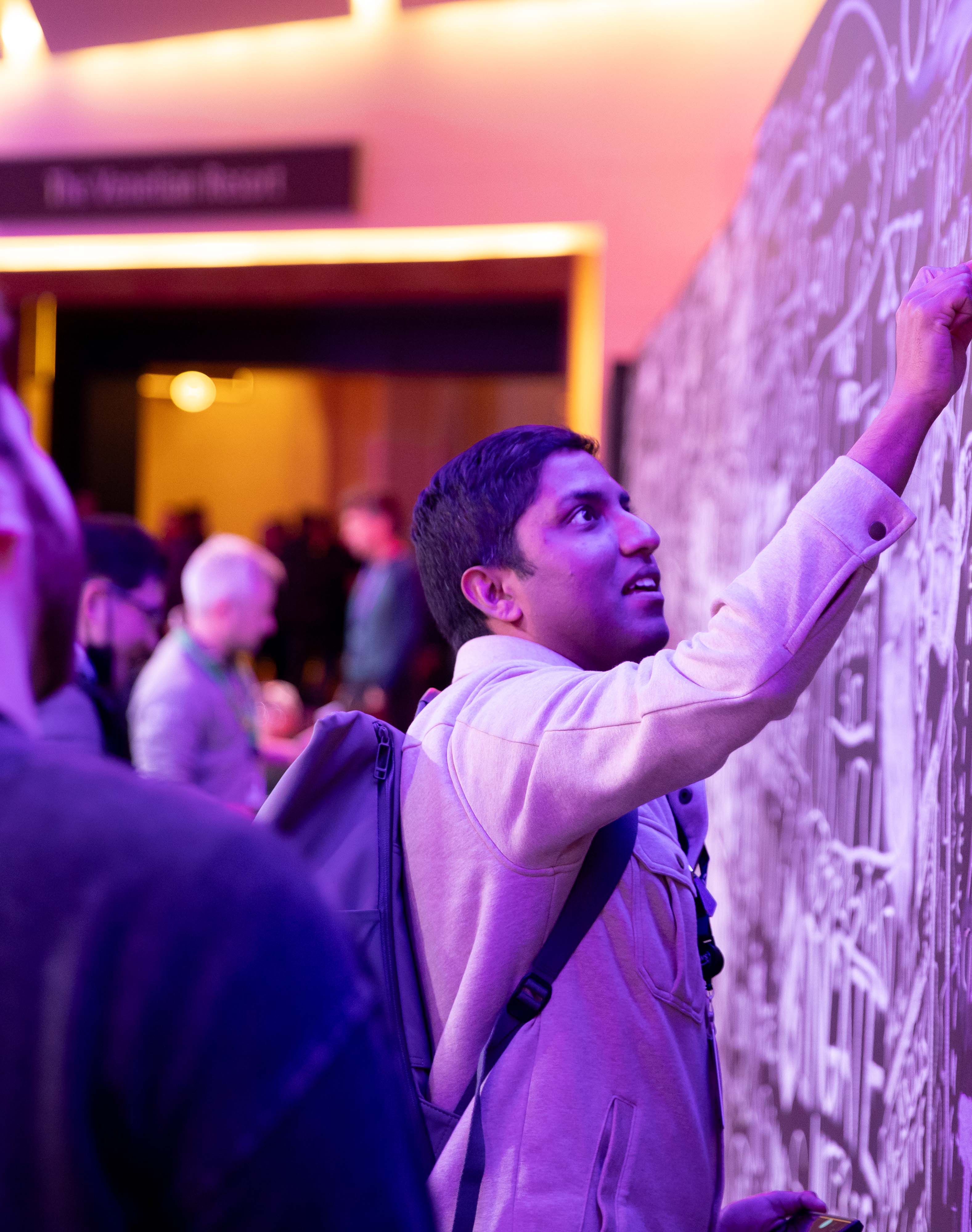 person writing on a doodle wall with chalk