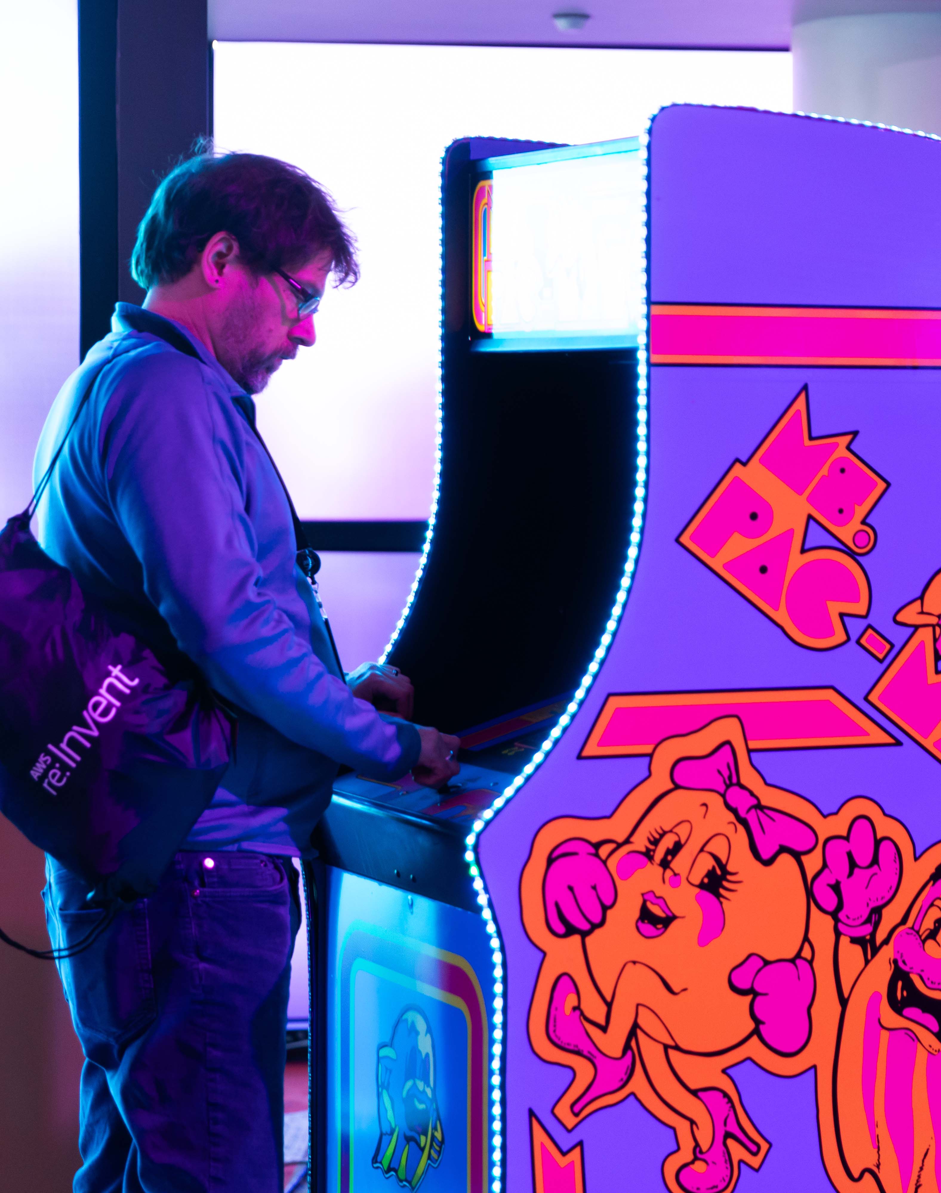 person playing pac man arcade game