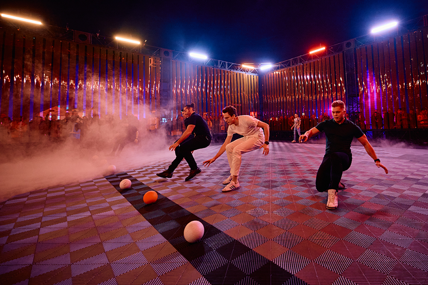 Players mid-game on the checkerboard Dodgeball court in haze