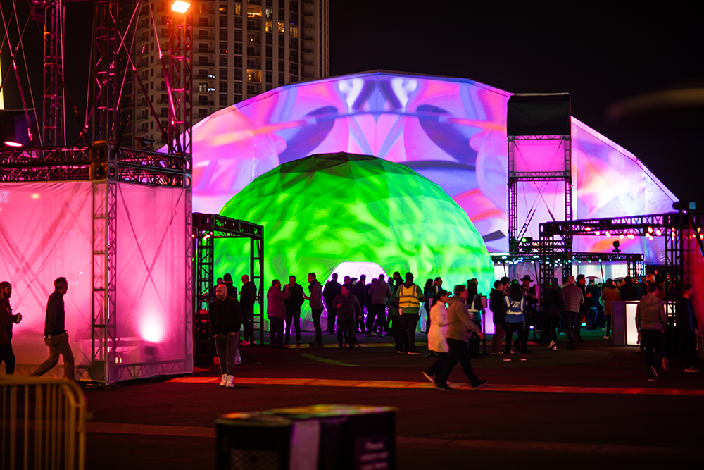 The Soundbath dome from outside, projection-mapped in green and pink