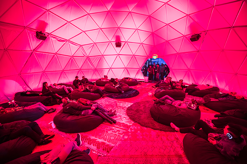 The Soundbath dome interior lit pink, beanbags arranged in a ring