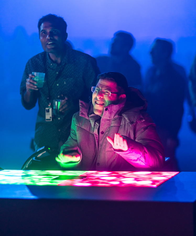 Two guests playing at a projected Button Mash table