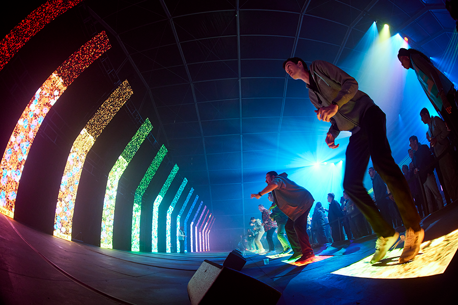 Guests on the Button Mash floor under an arc of coloured light