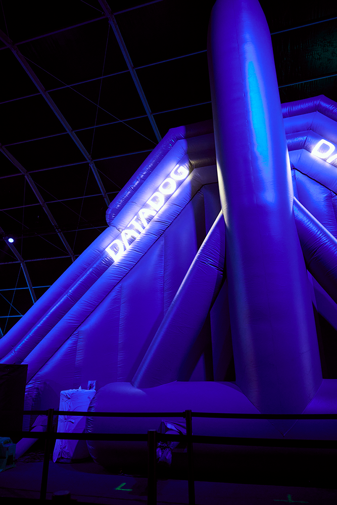 The Gianter Slide inflatable lit purple, sponsor branding on the tower