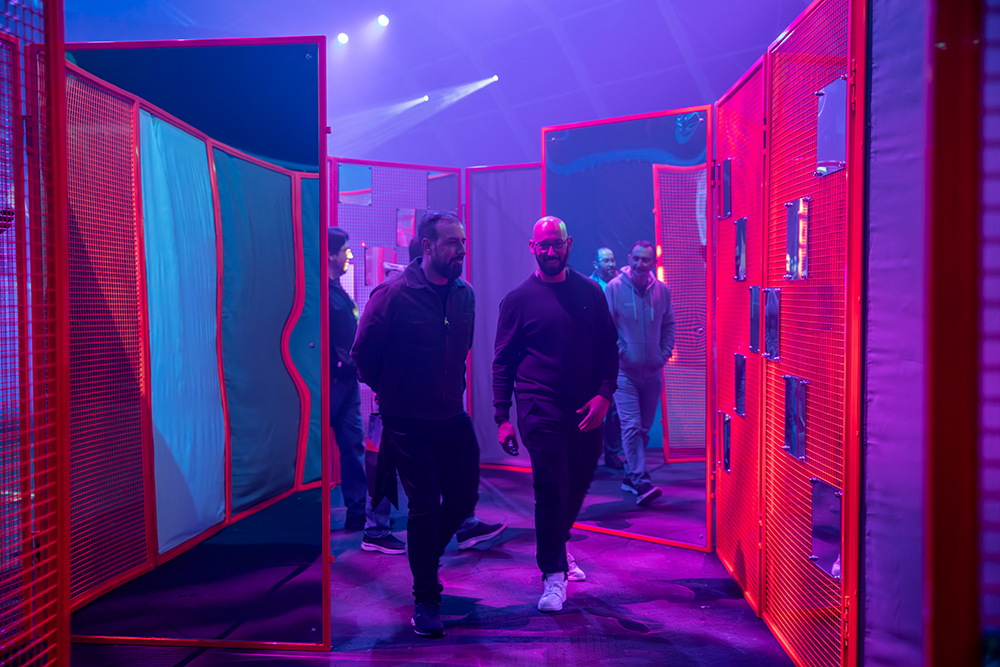Two guests walking out of the red mesh Labyrinth