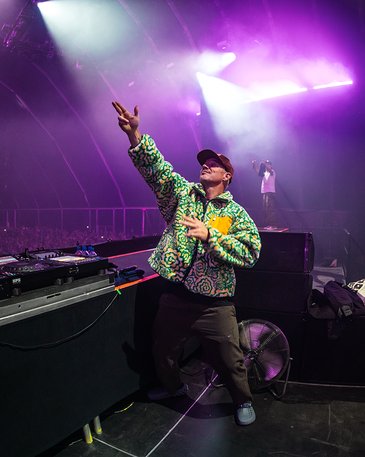 A man standing on a stage with his arms in the air.