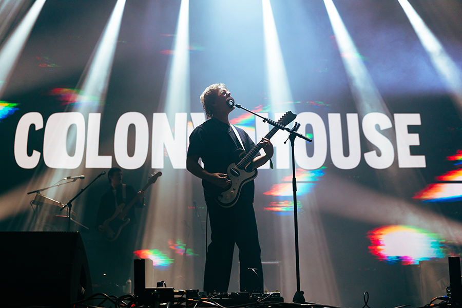 A man standing on a stage with a guitar.