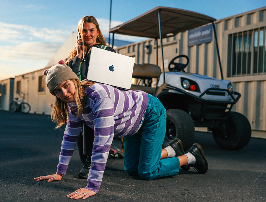 A woman on a cell phone and a man on a golf cart.