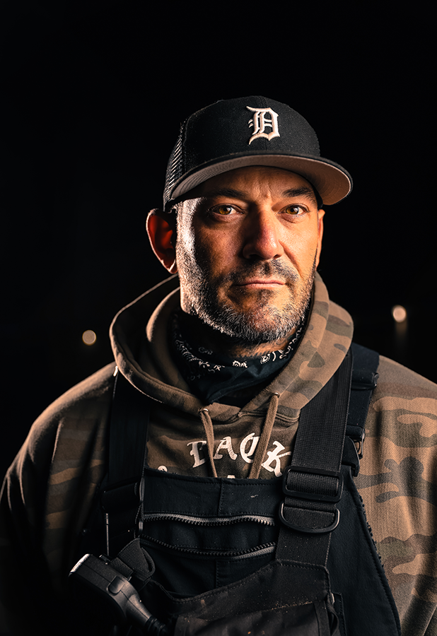 A man wearing a hat and a camo jacket.