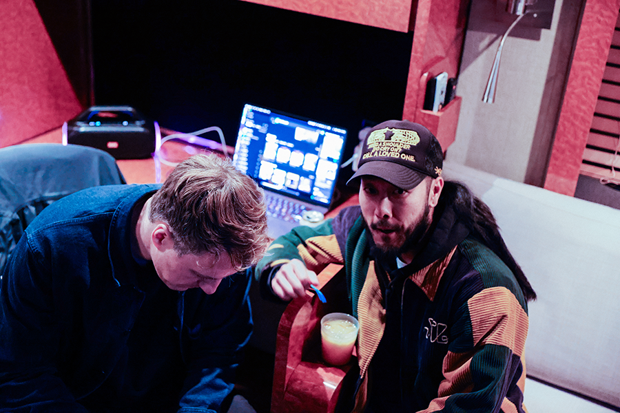 Two men sitting on a couch looking at something.