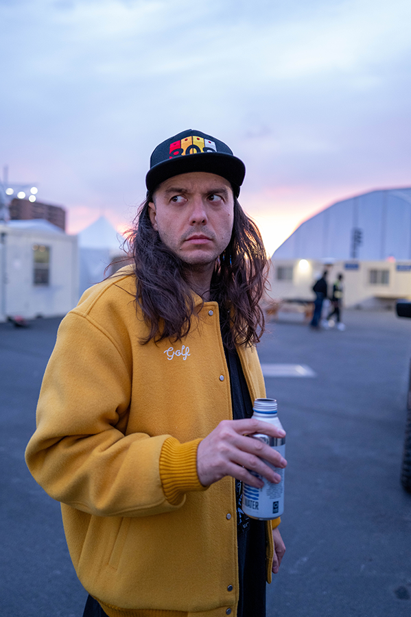 A man in a yellow jacket holding a can of soda.