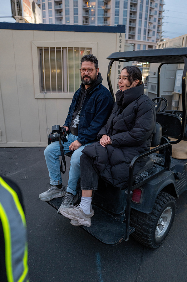 A man and a woman sitting on a golf cart.