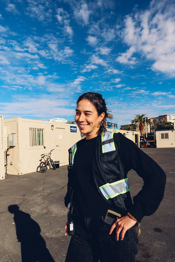A woman standing in a parking lot next to a building.