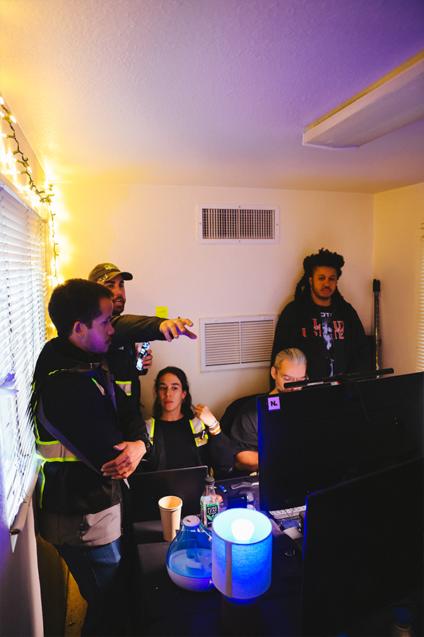 A group of people sitting around a table with laptops.