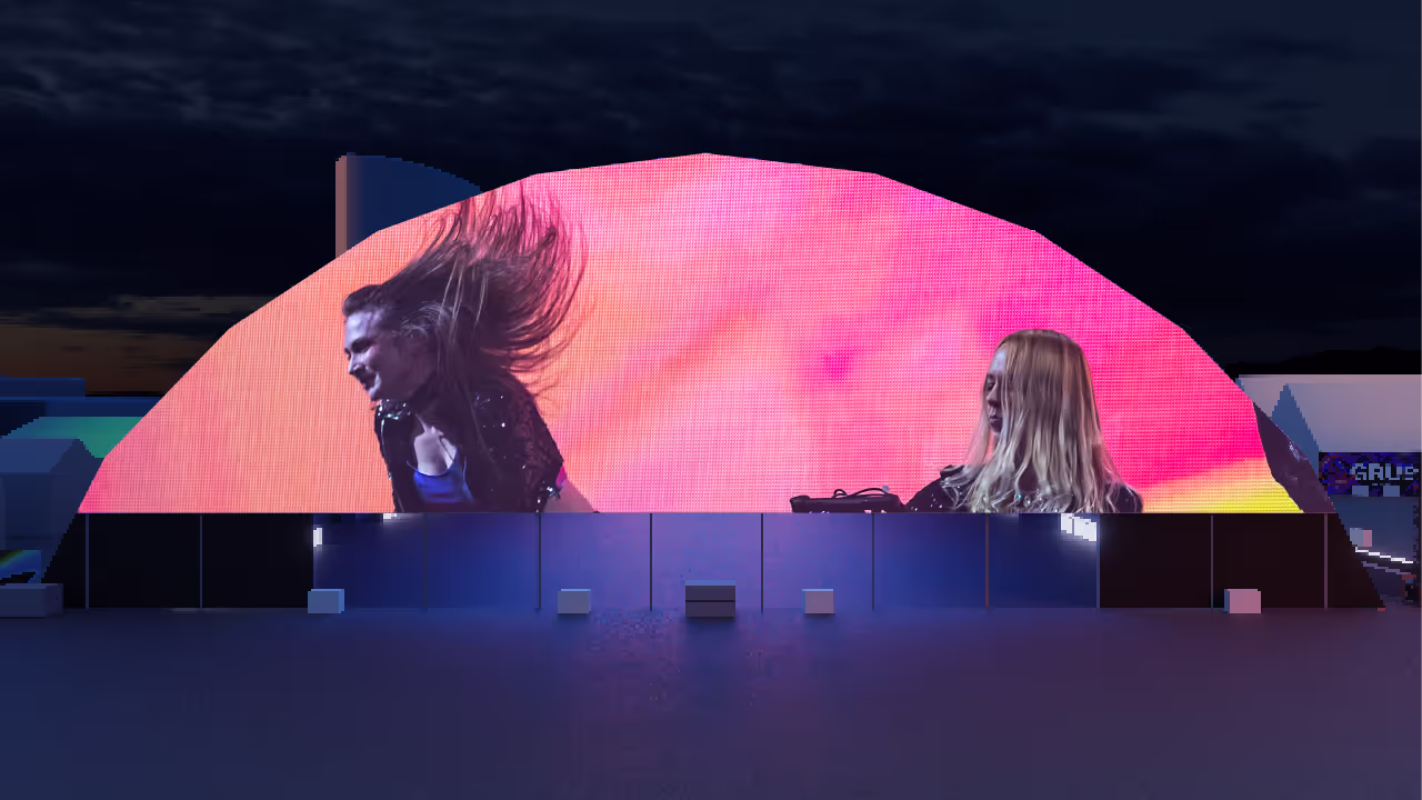 Two women are sitting in front of a large screen.