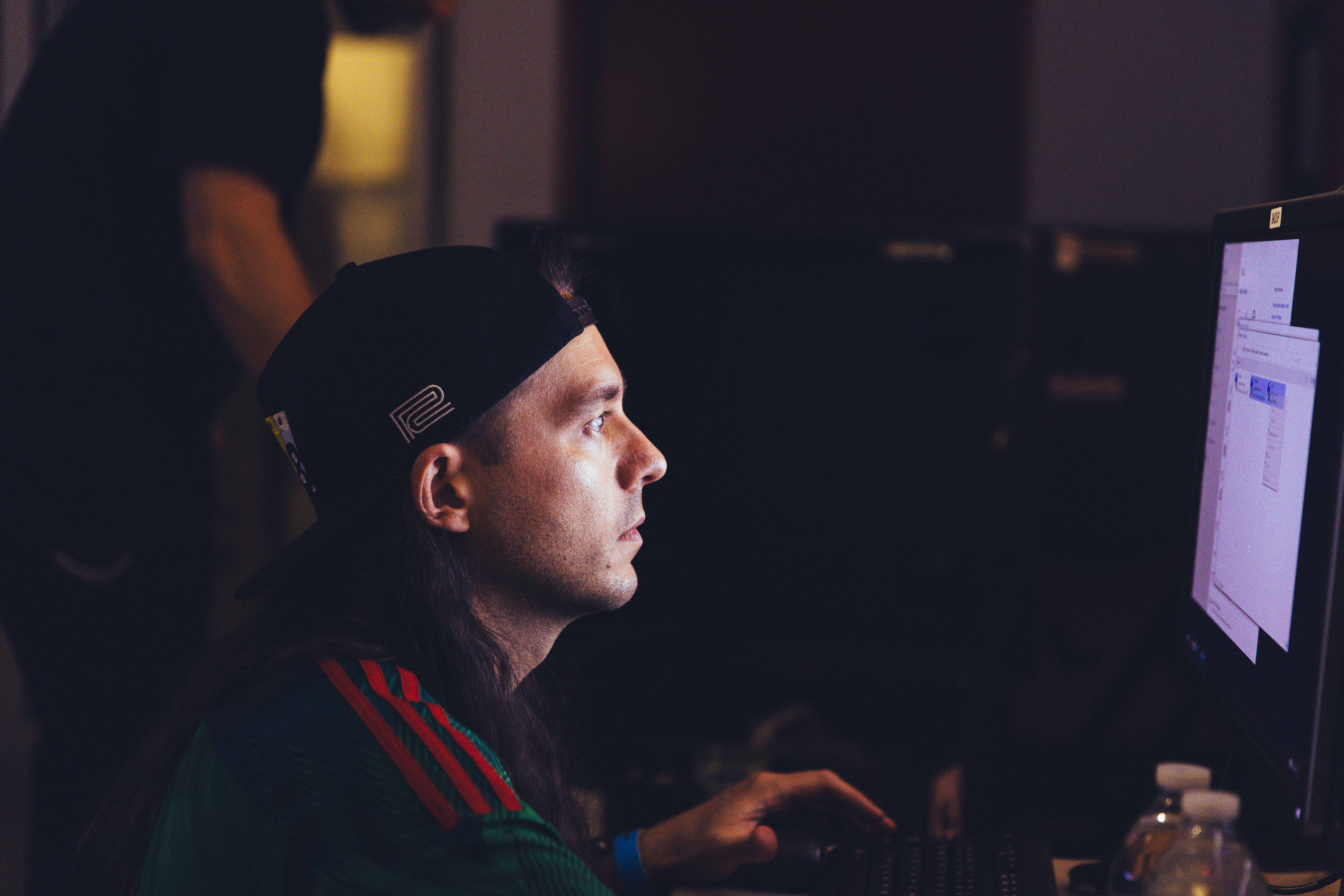 a man looking at a computer in a dimly lit room