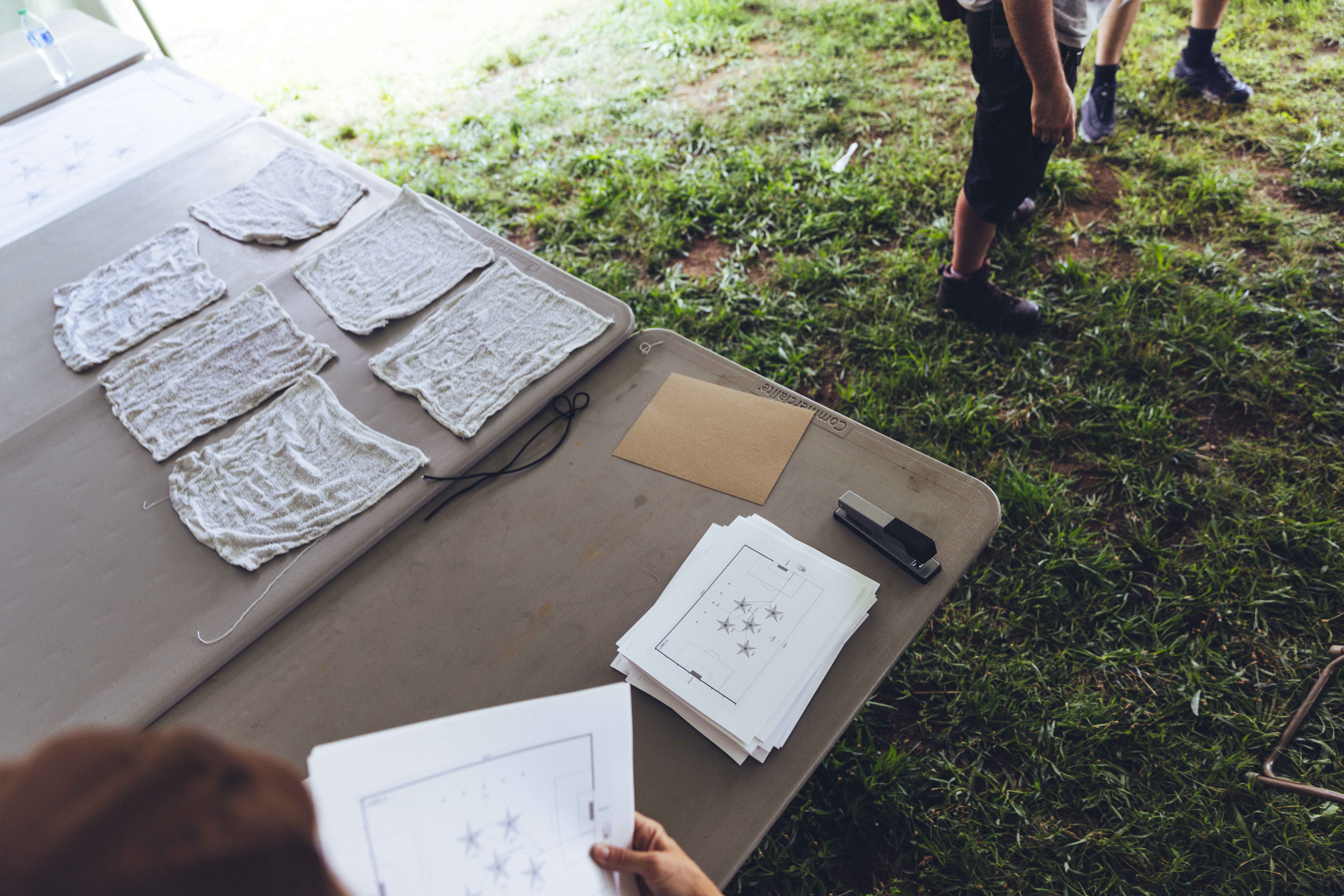 a table outside with papers and washcloths on it