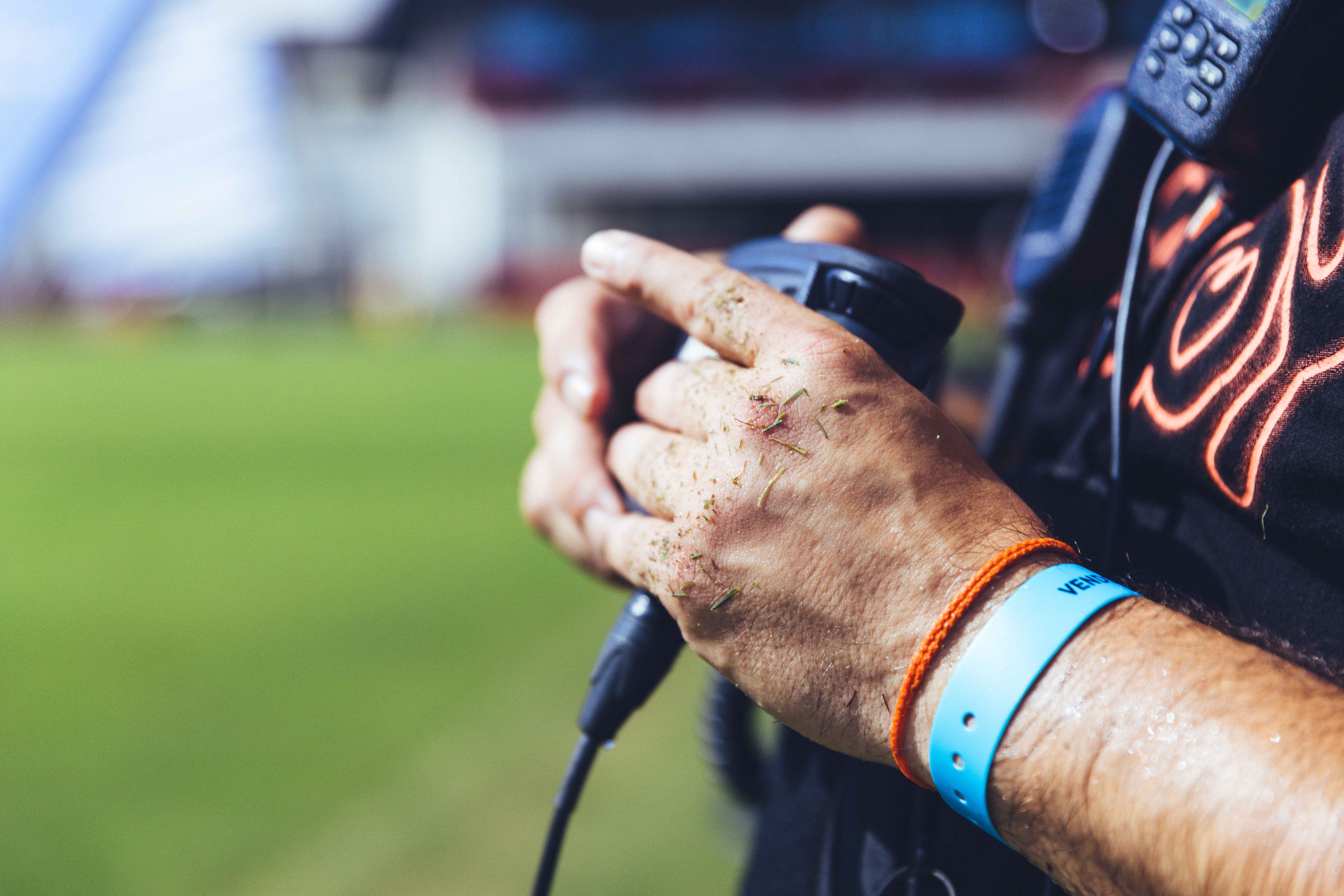 closeup of hands holding a microphone on a field