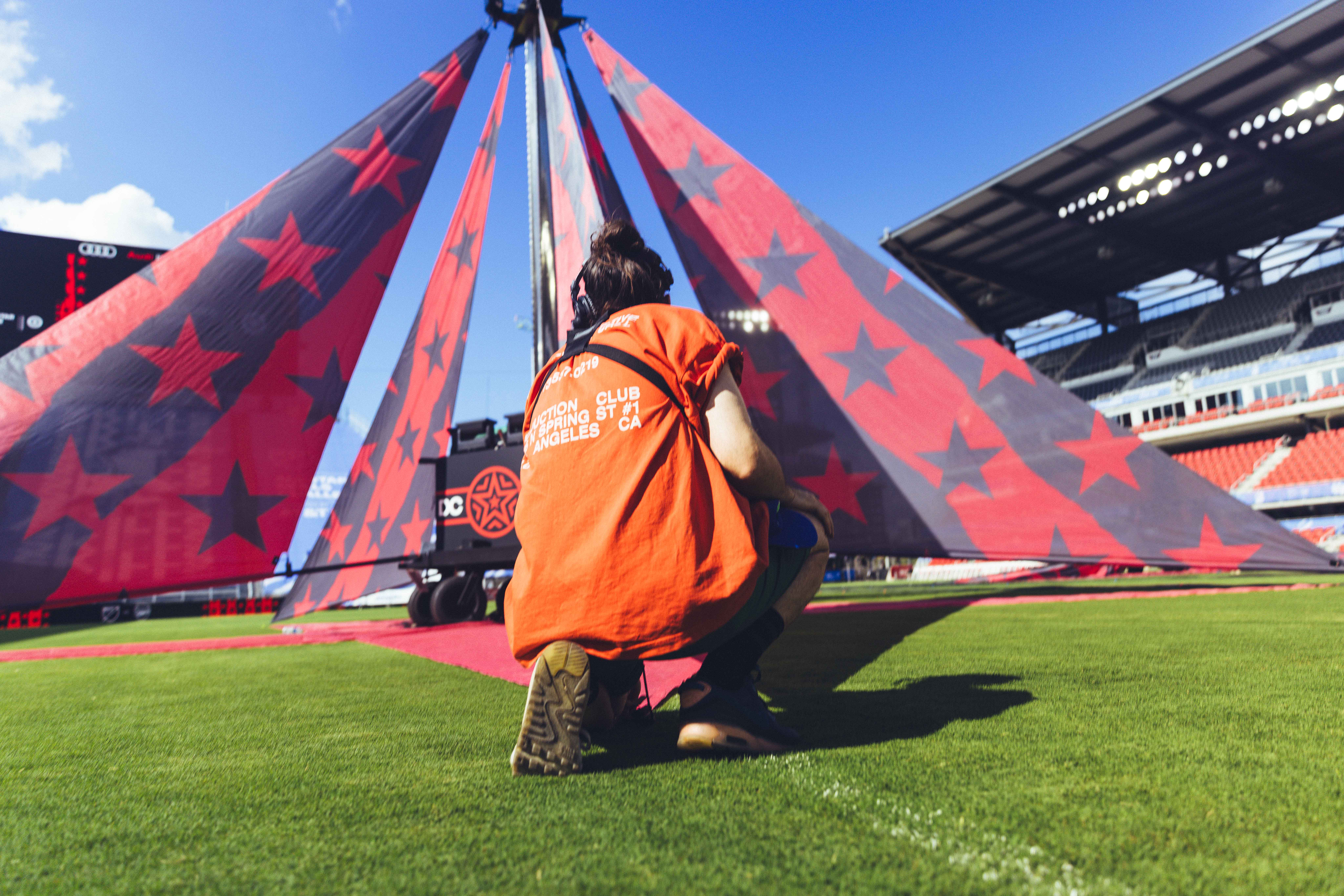 person in orange coat standing in a soccer field