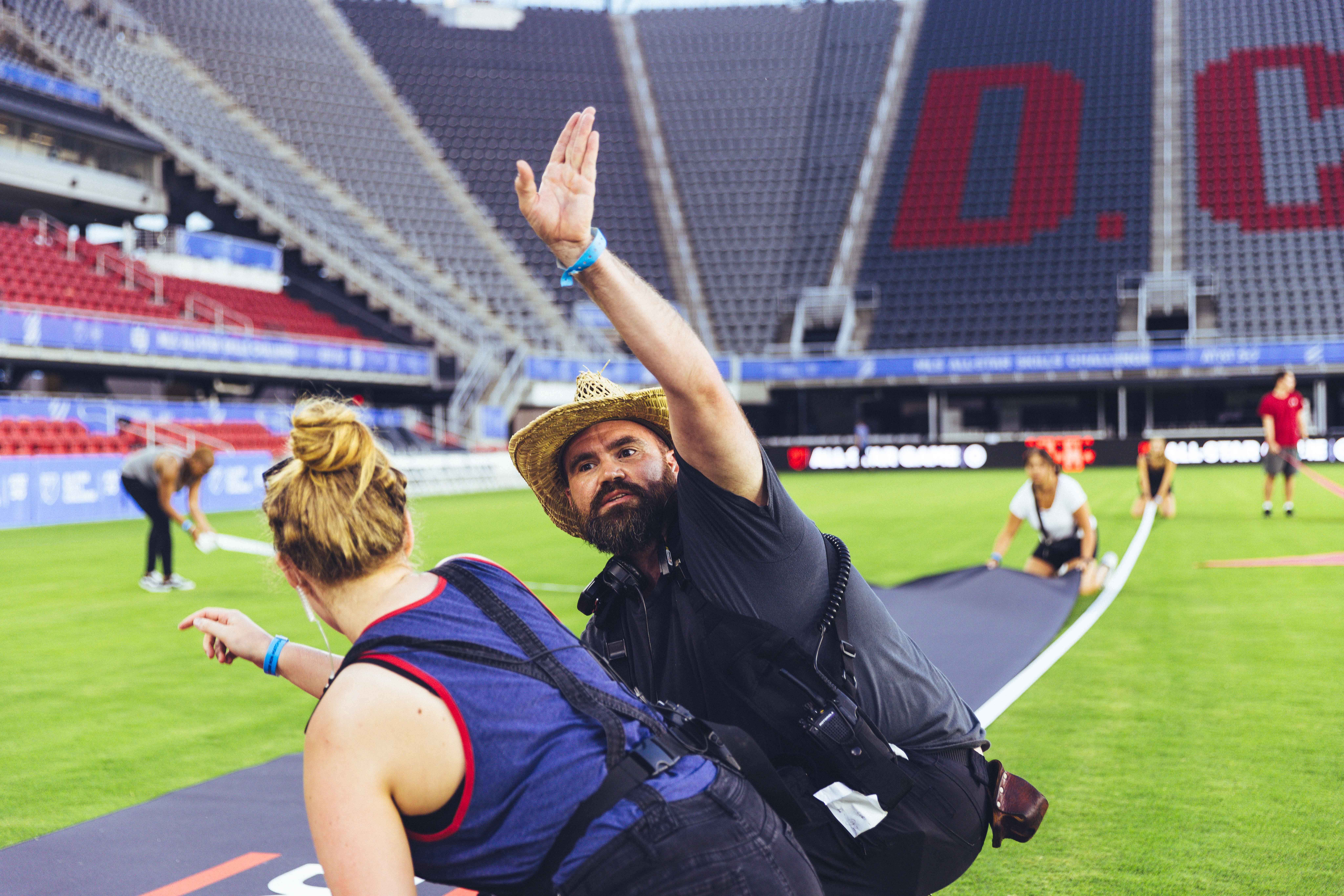 two people waving in the middle of a soccer field