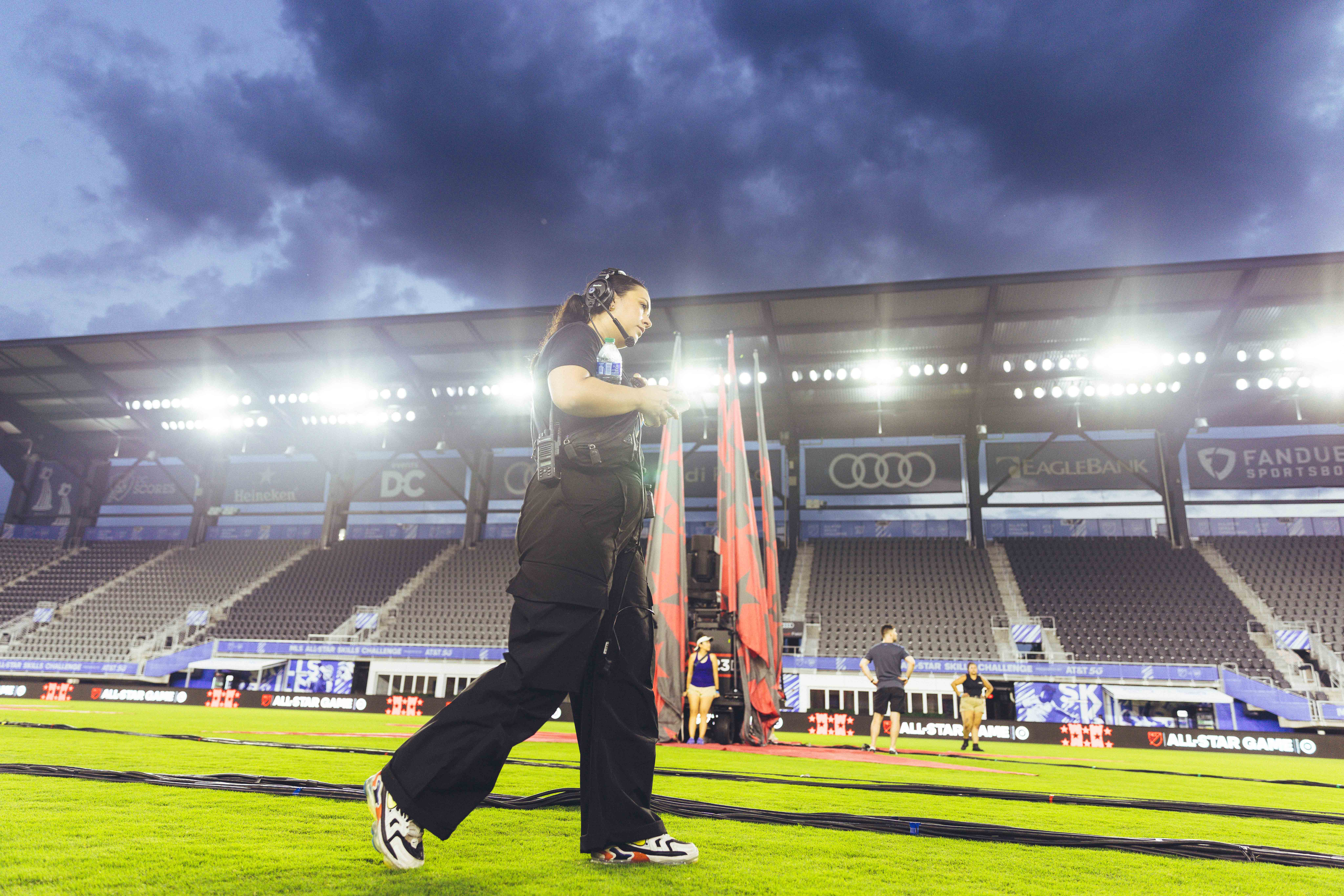 person walking across a soccer field before the game