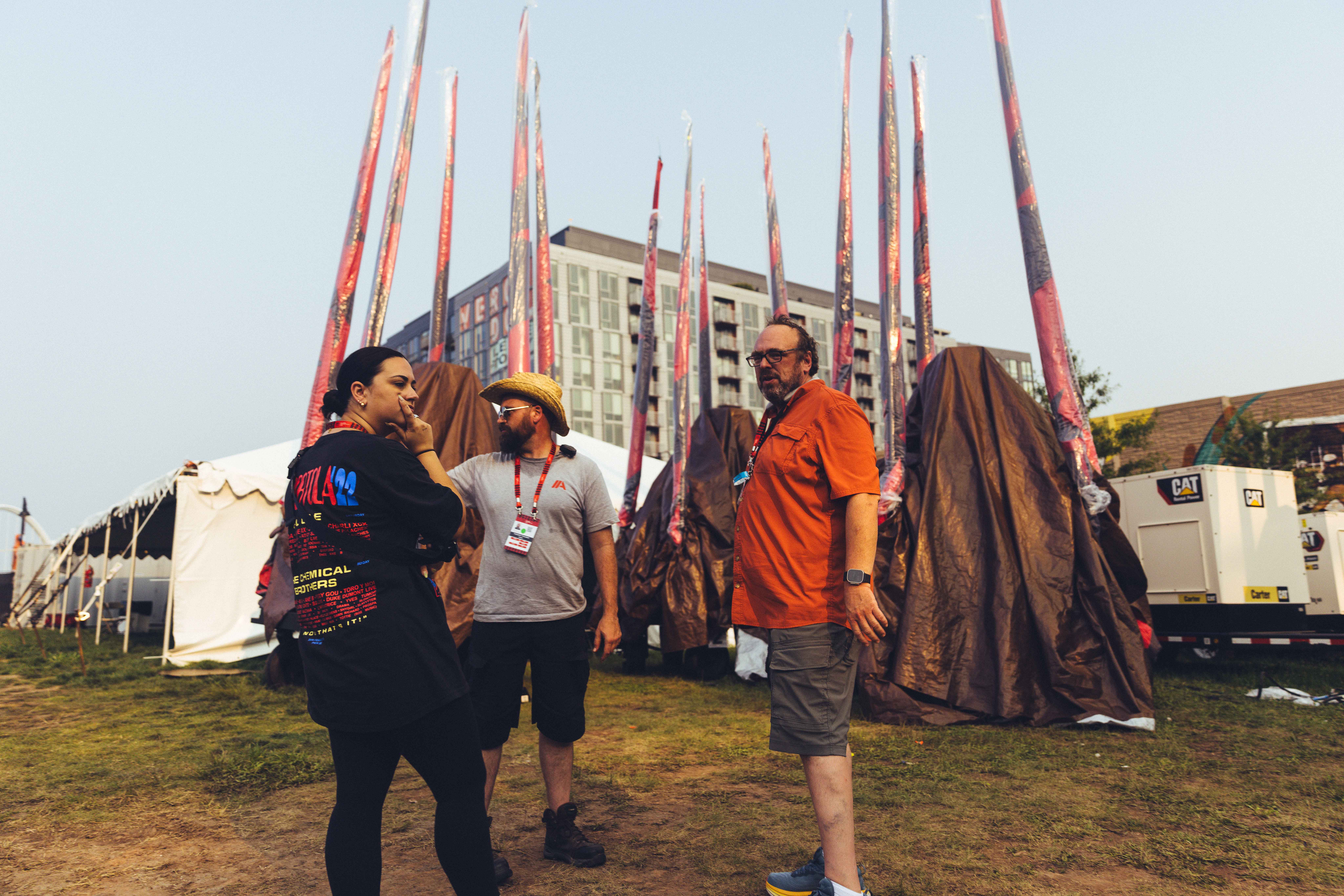 people standing outside with black and red flags in the background