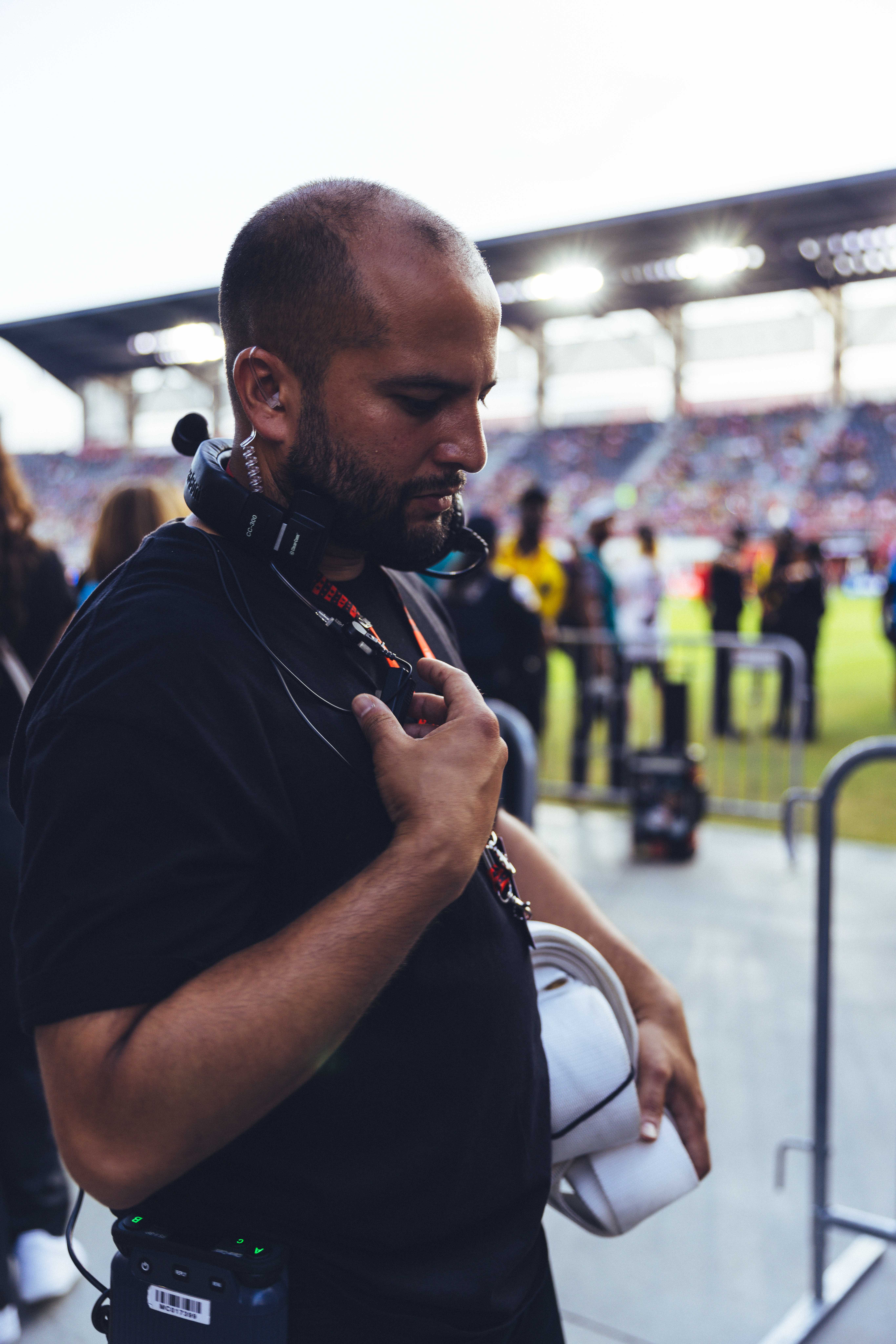person in black standing on the side of a soccer field