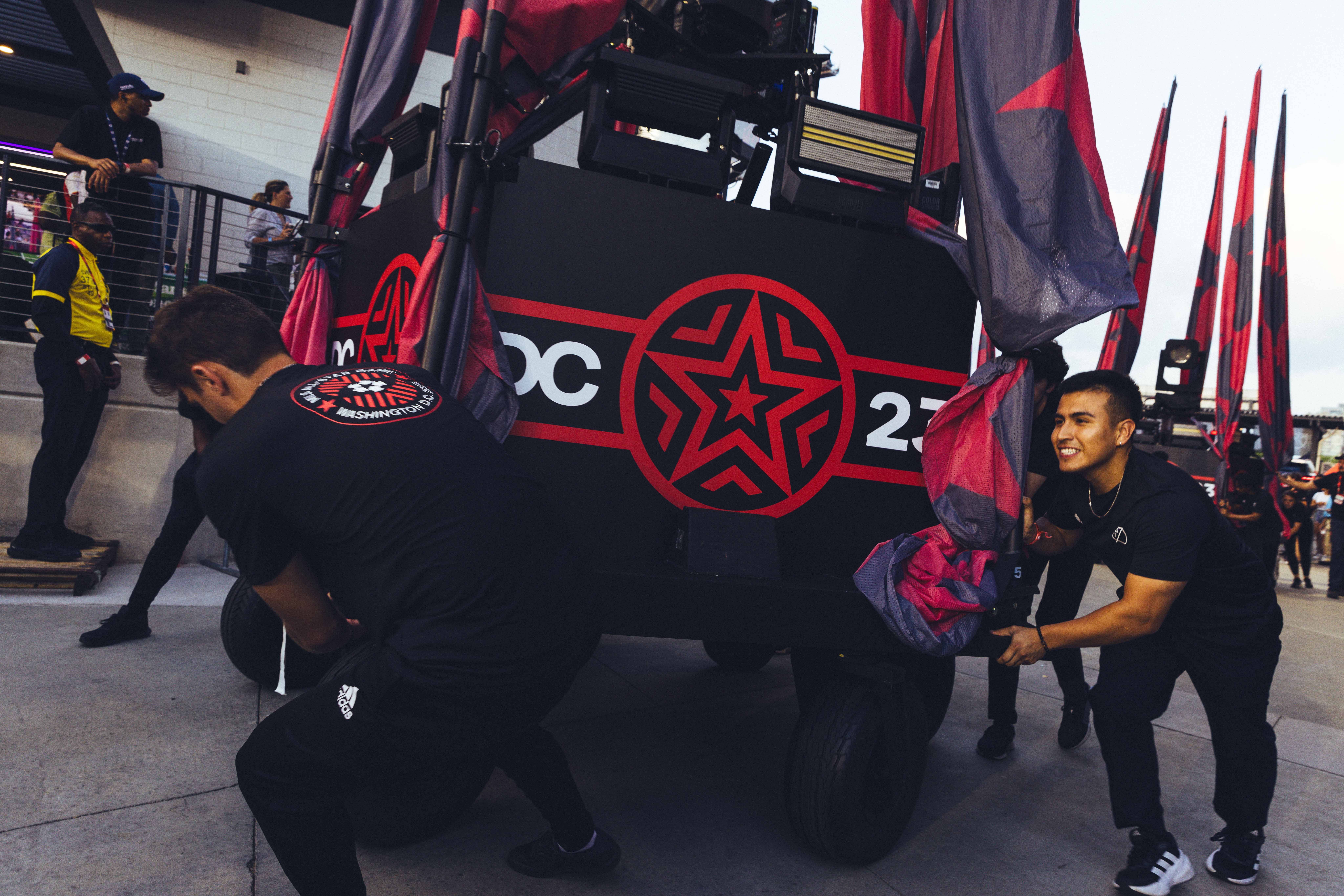 two people dressed in black posing behind a truck
