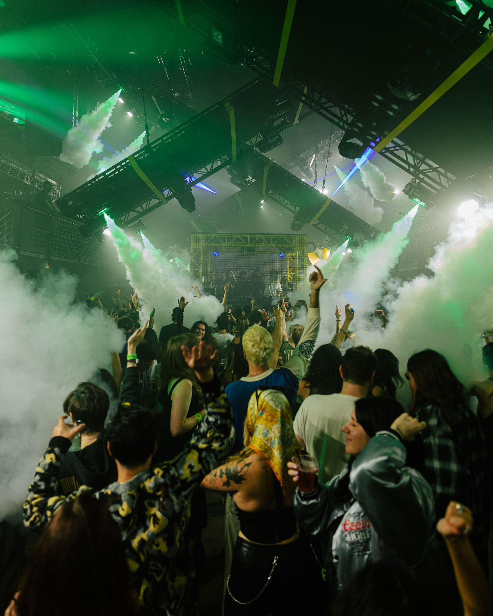 People standing around rave filled with smoke