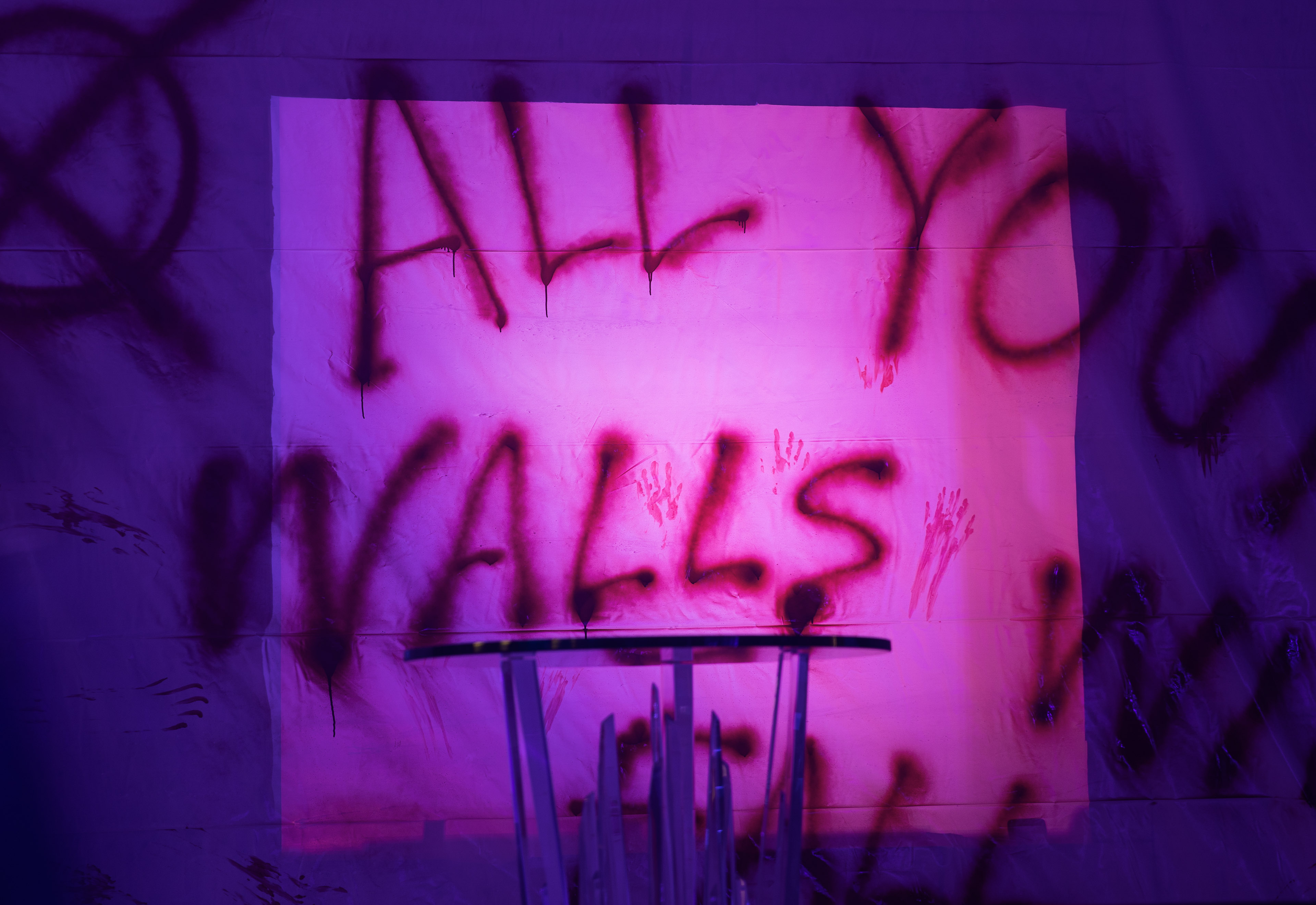 Purple-lit wall with graffiti text reading 'All Walls' and red handprints.