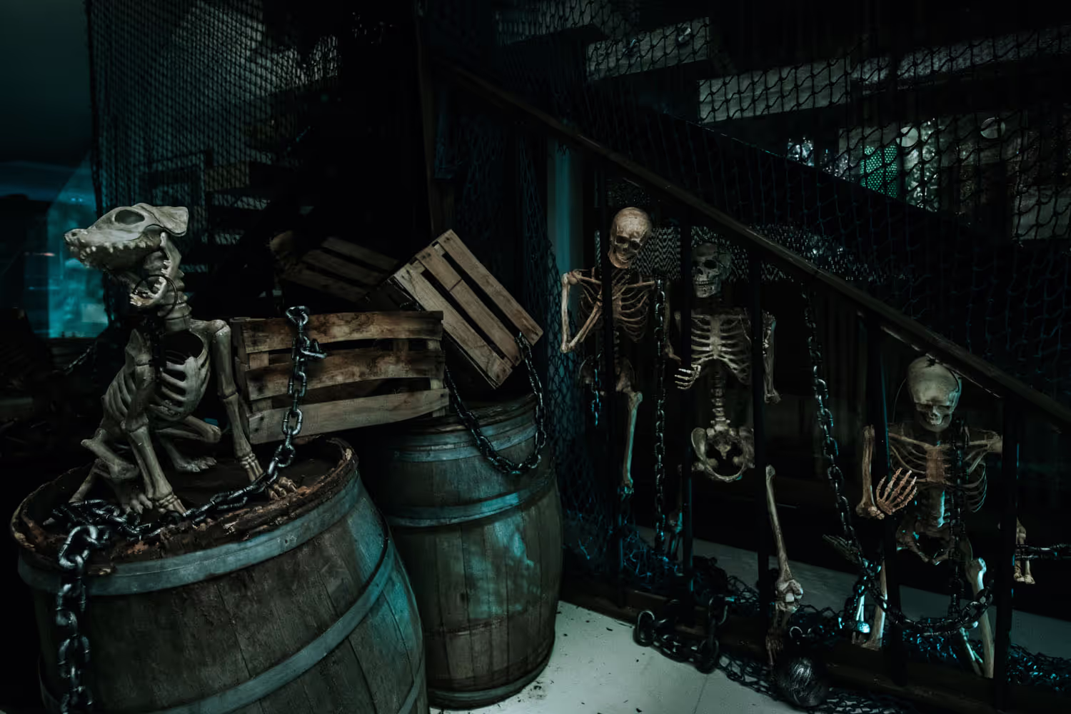 A group of skeleton figurines sitting on top of a barrel.