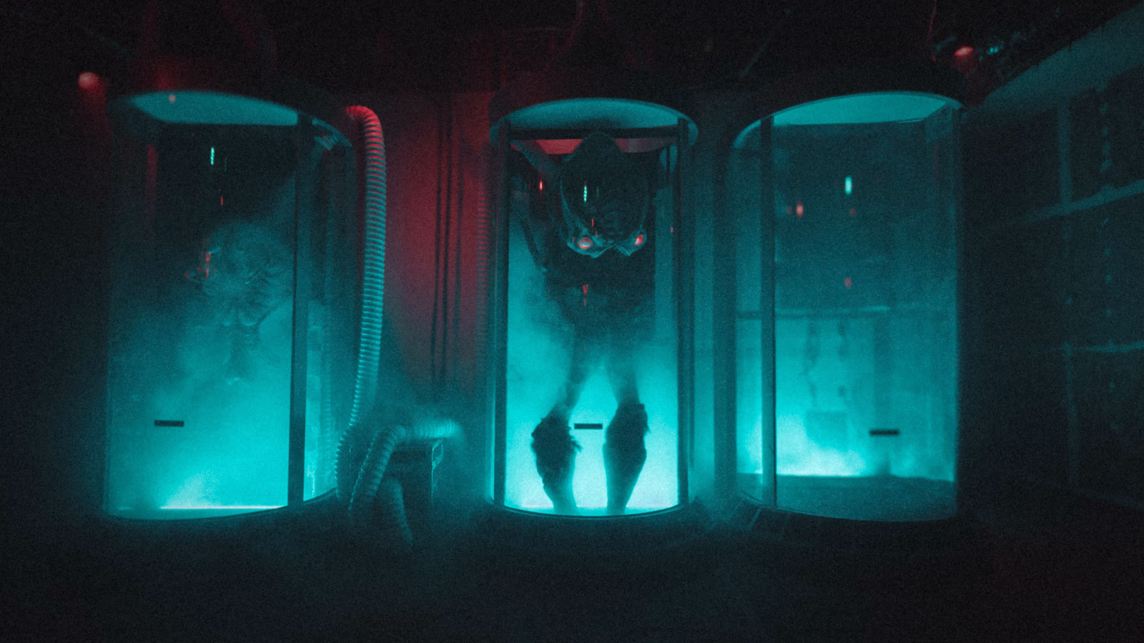 aliens held in large tubes with blue lighting