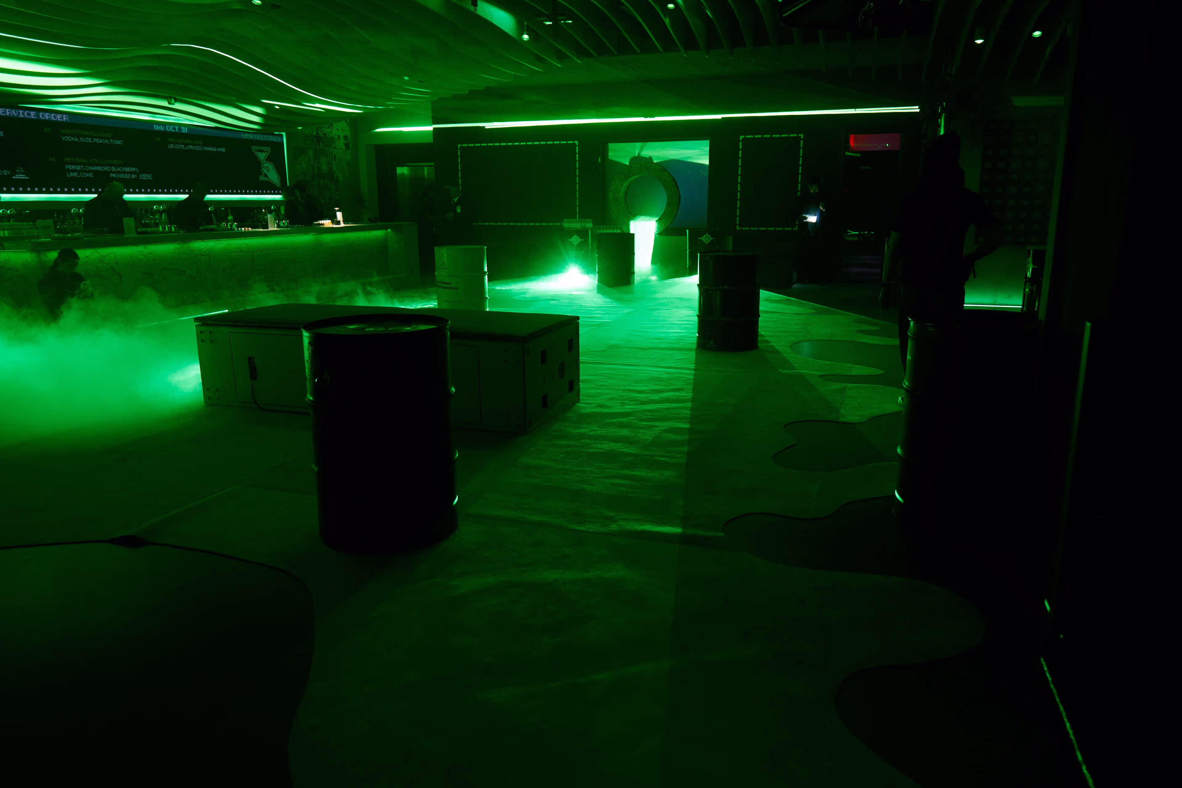 A dimly lit room with a green light coming from the ceiling.