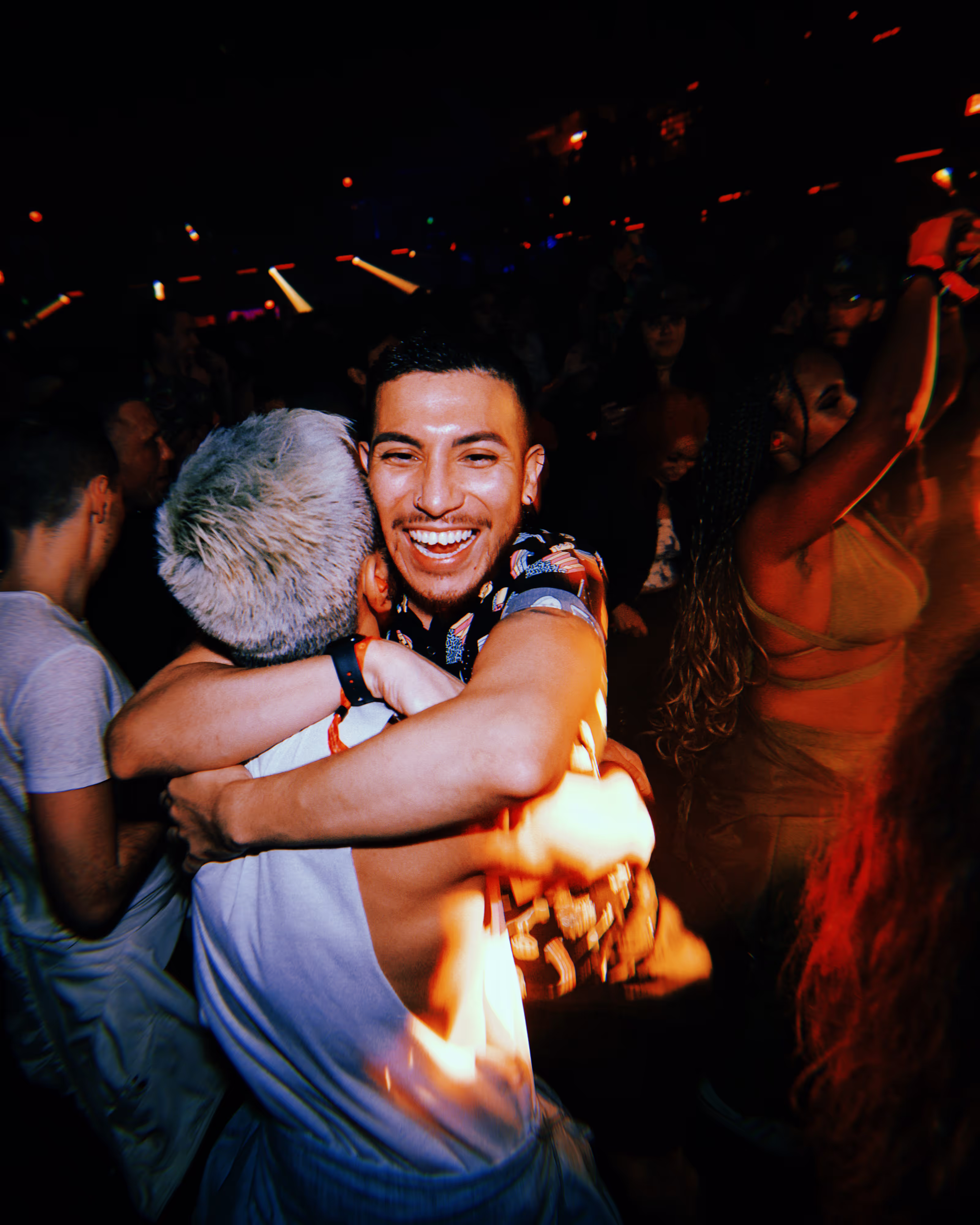 who men hugging at an underground rave