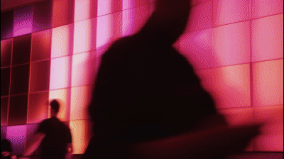 Animation of people walking across a lit wall