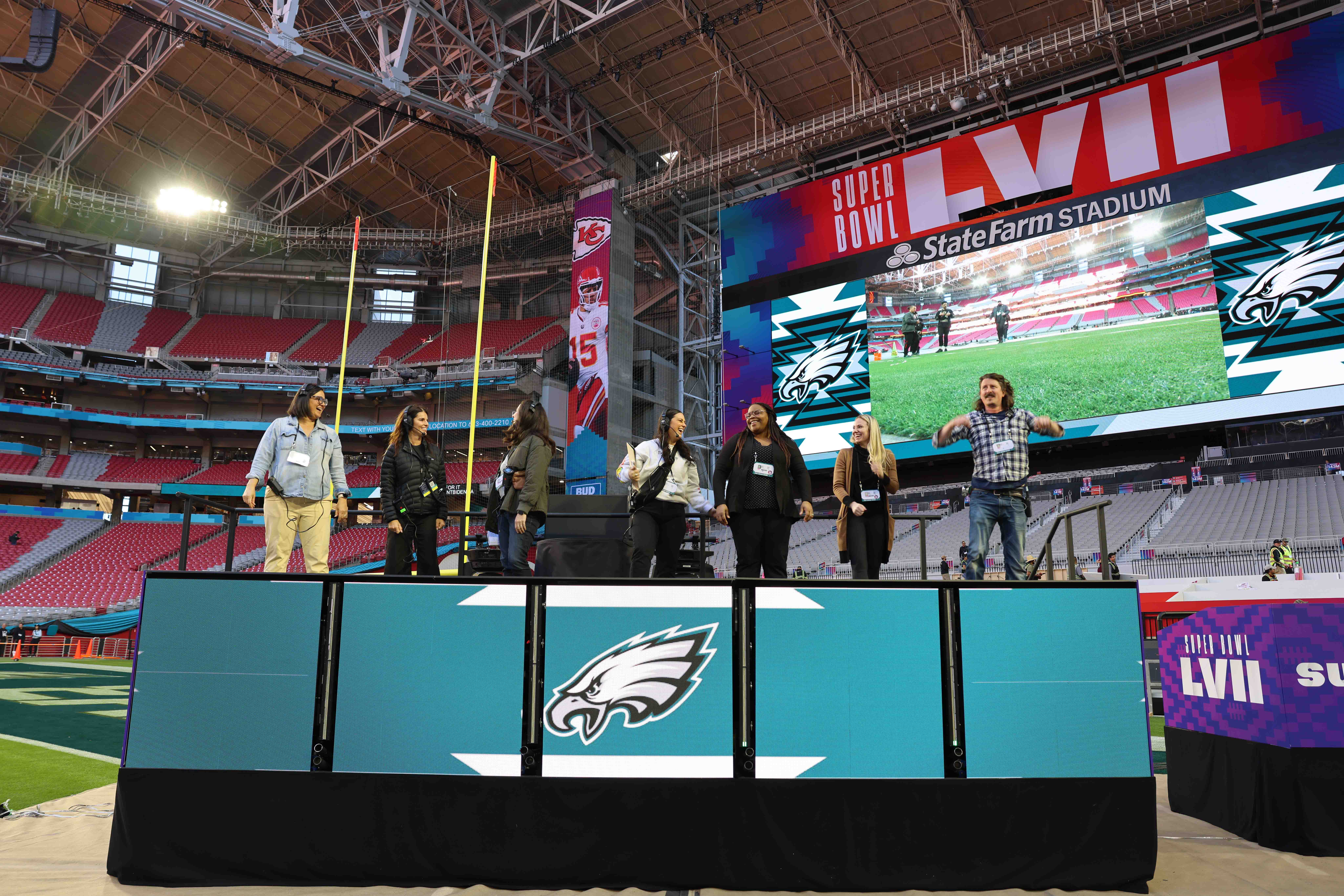 a group of people standing on a stage in front of a large screen