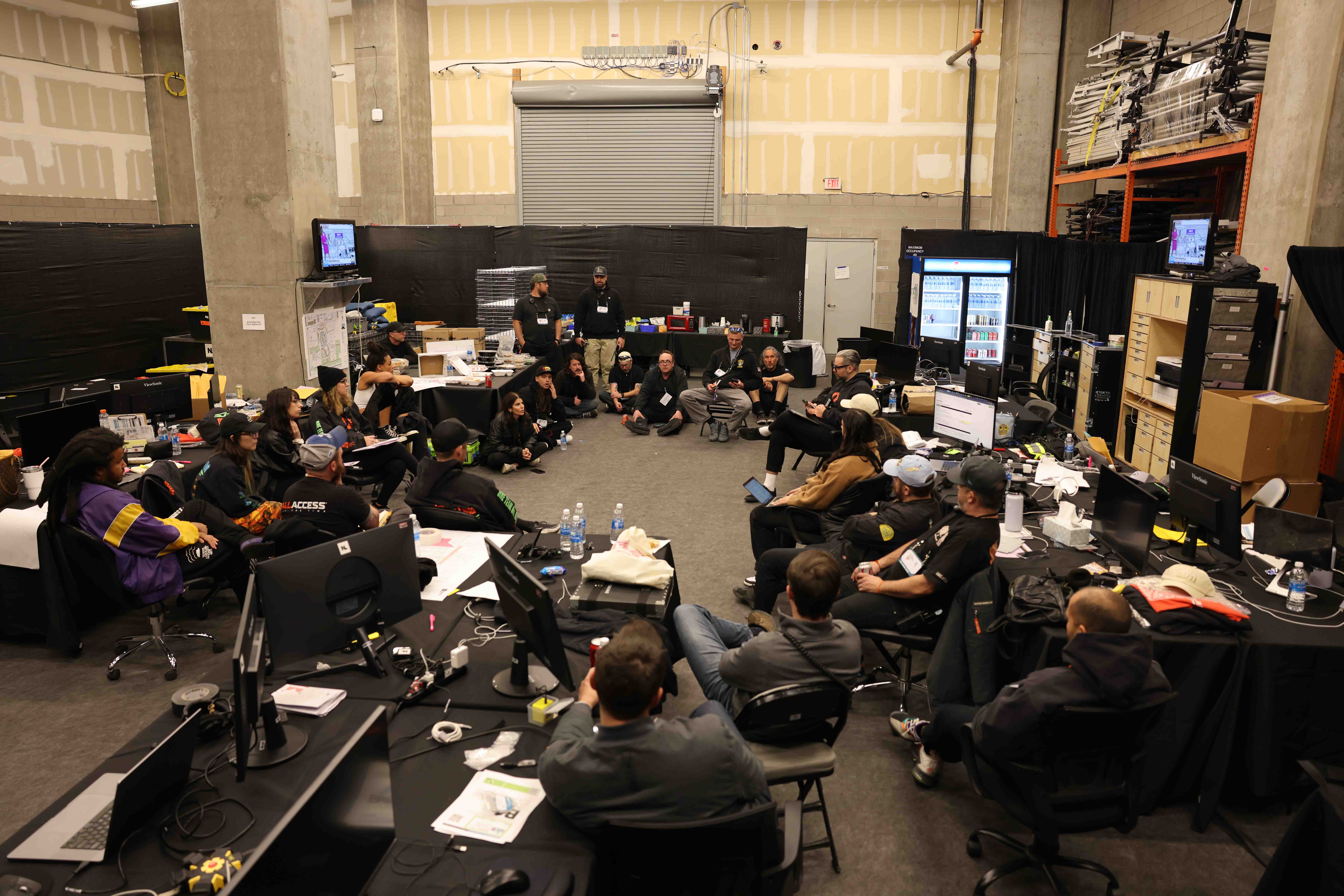 a group of people sitting in a room with computers