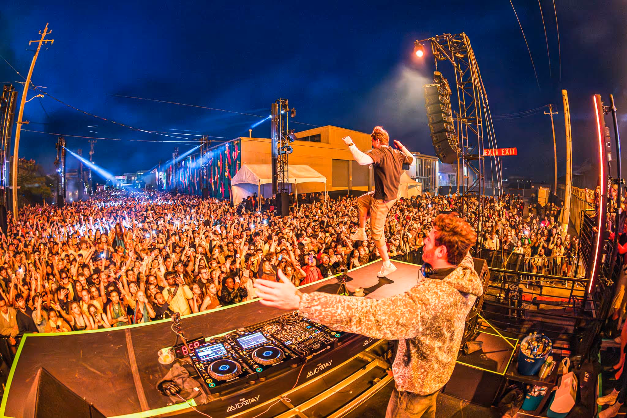 Man on DJ decks in front of crowd