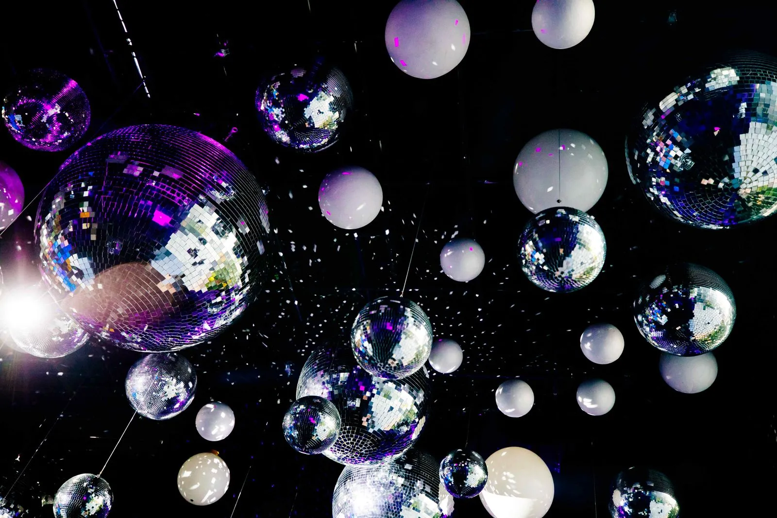 A bunch of disco balls floating in the air.