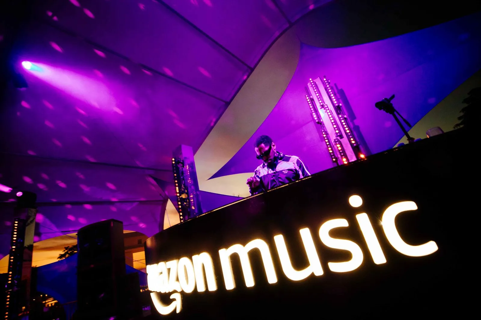 A man standing in front of a sign that says amazon music.