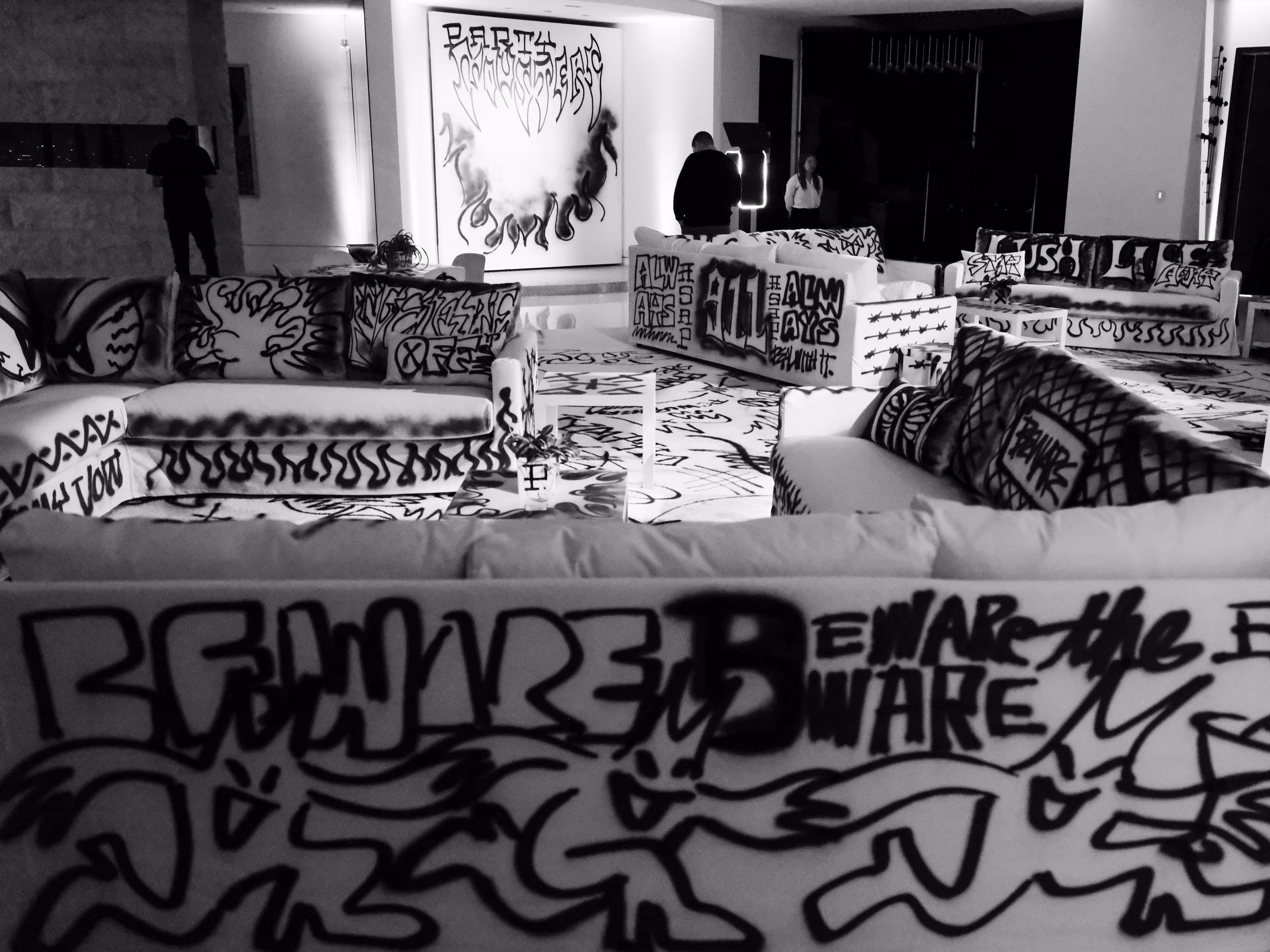 A black and white photo of graffiti covered couches.