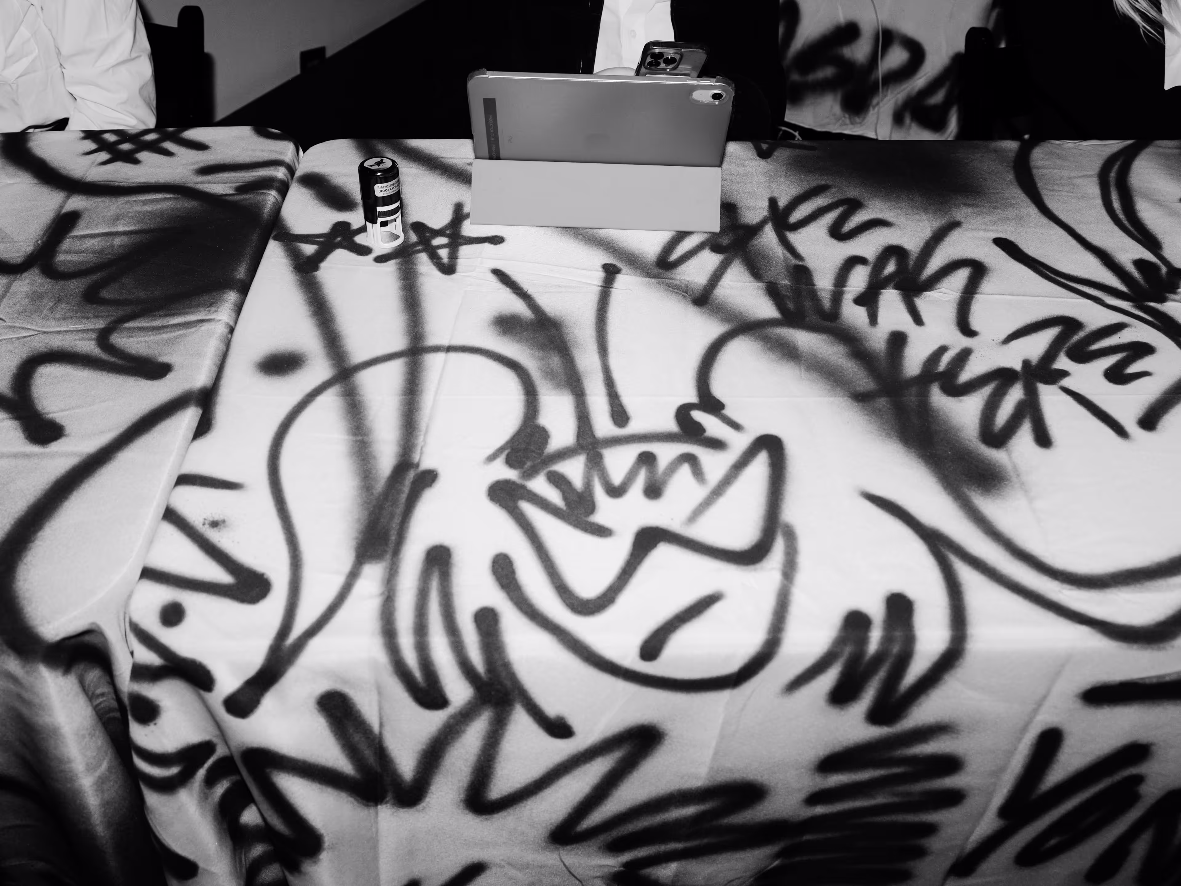 A table with a laptop on it covered in graffiti.