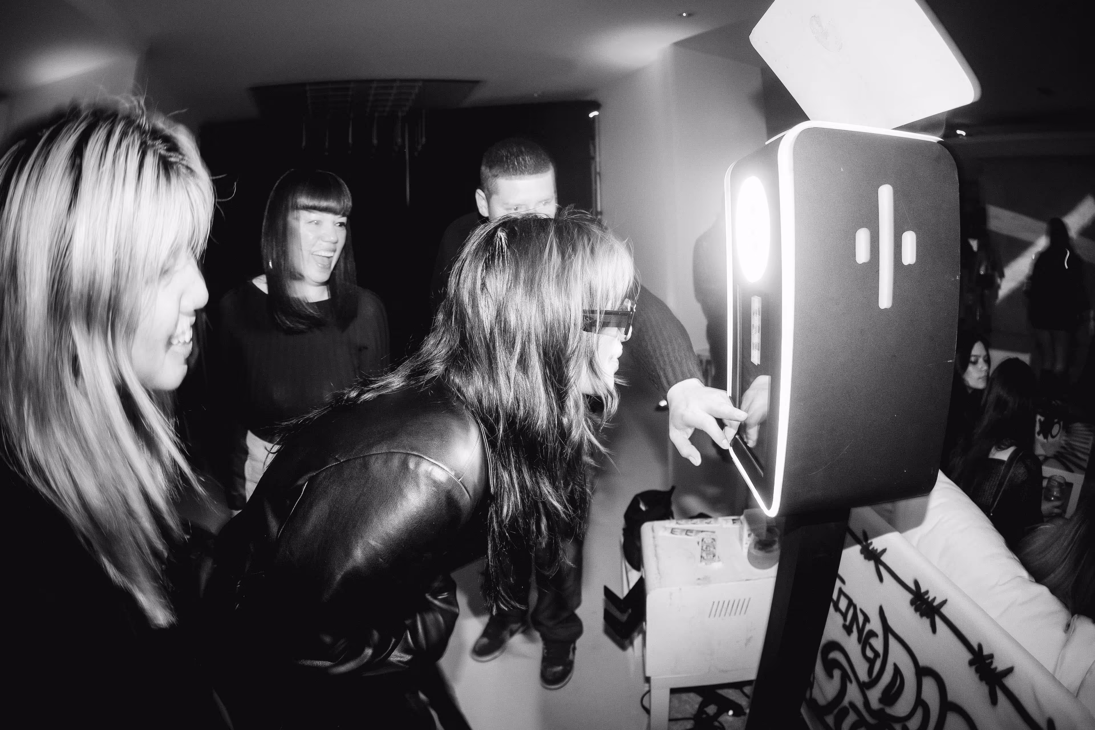 A group of people standing around a refrigerator.