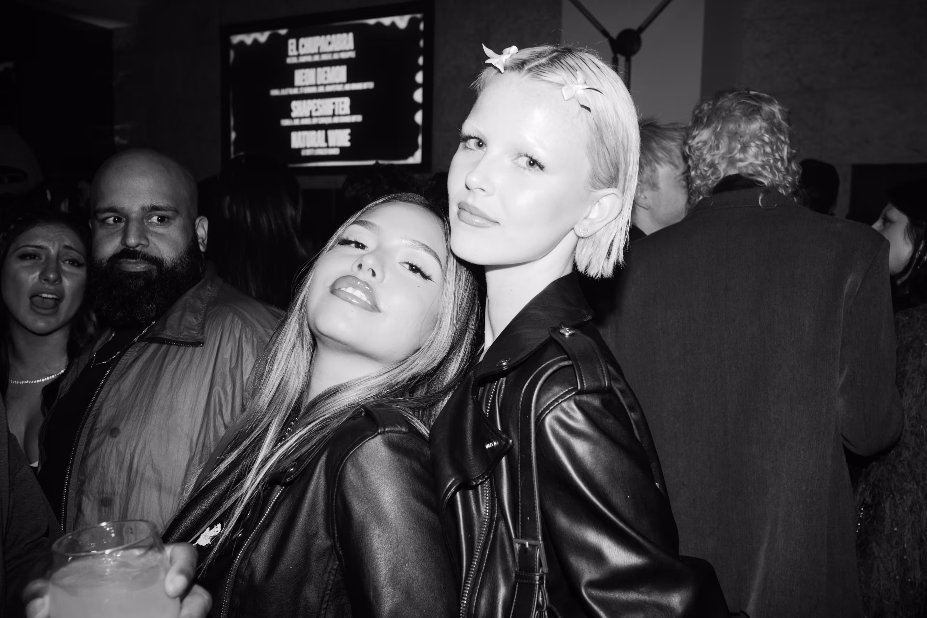 Two women standing next to each other at a party.