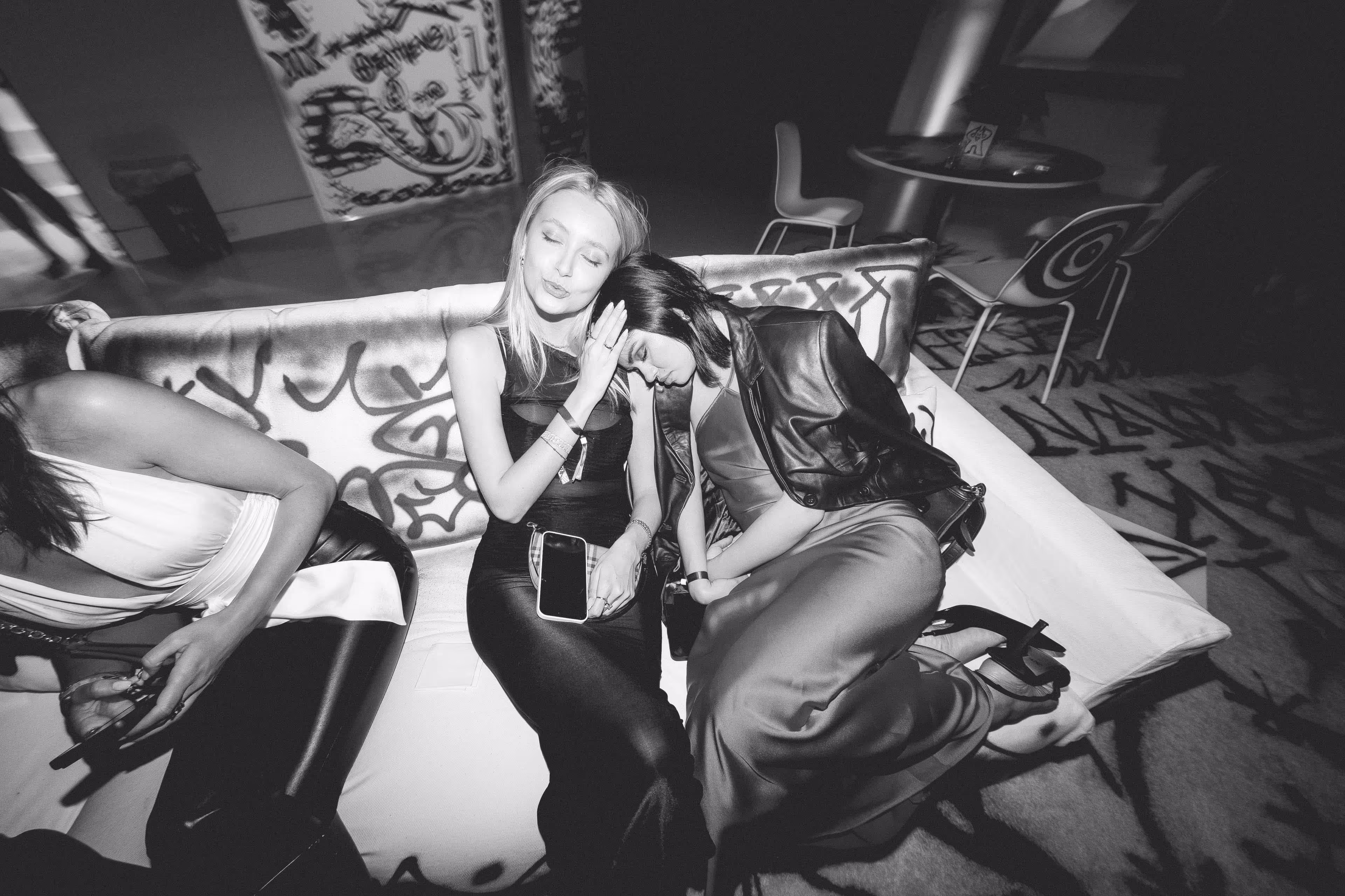 A black and white photo of two women sitting on a couch.