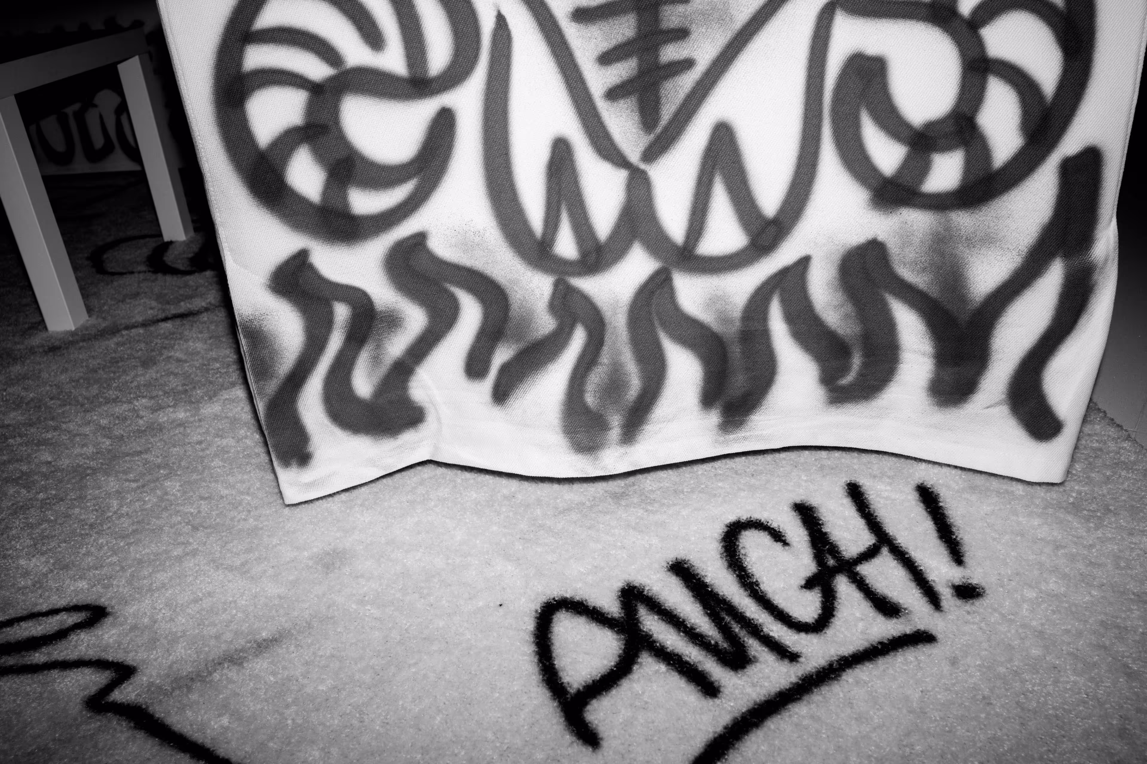 A black and white photo of graffiti on a wall.