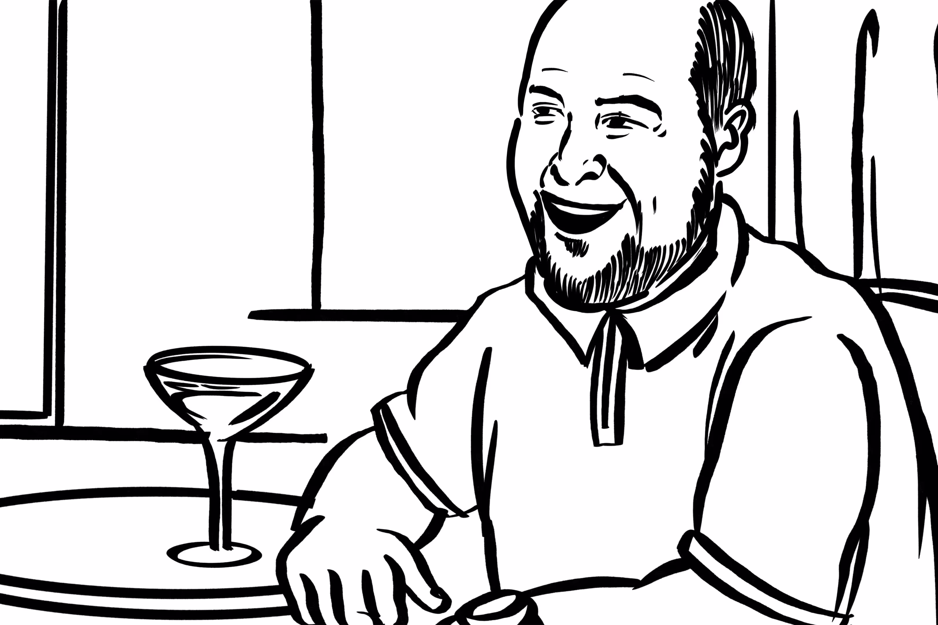 man sitting at a table with a martini in his hand